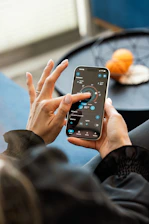 Hands controlling smart home devices using a smartphone.