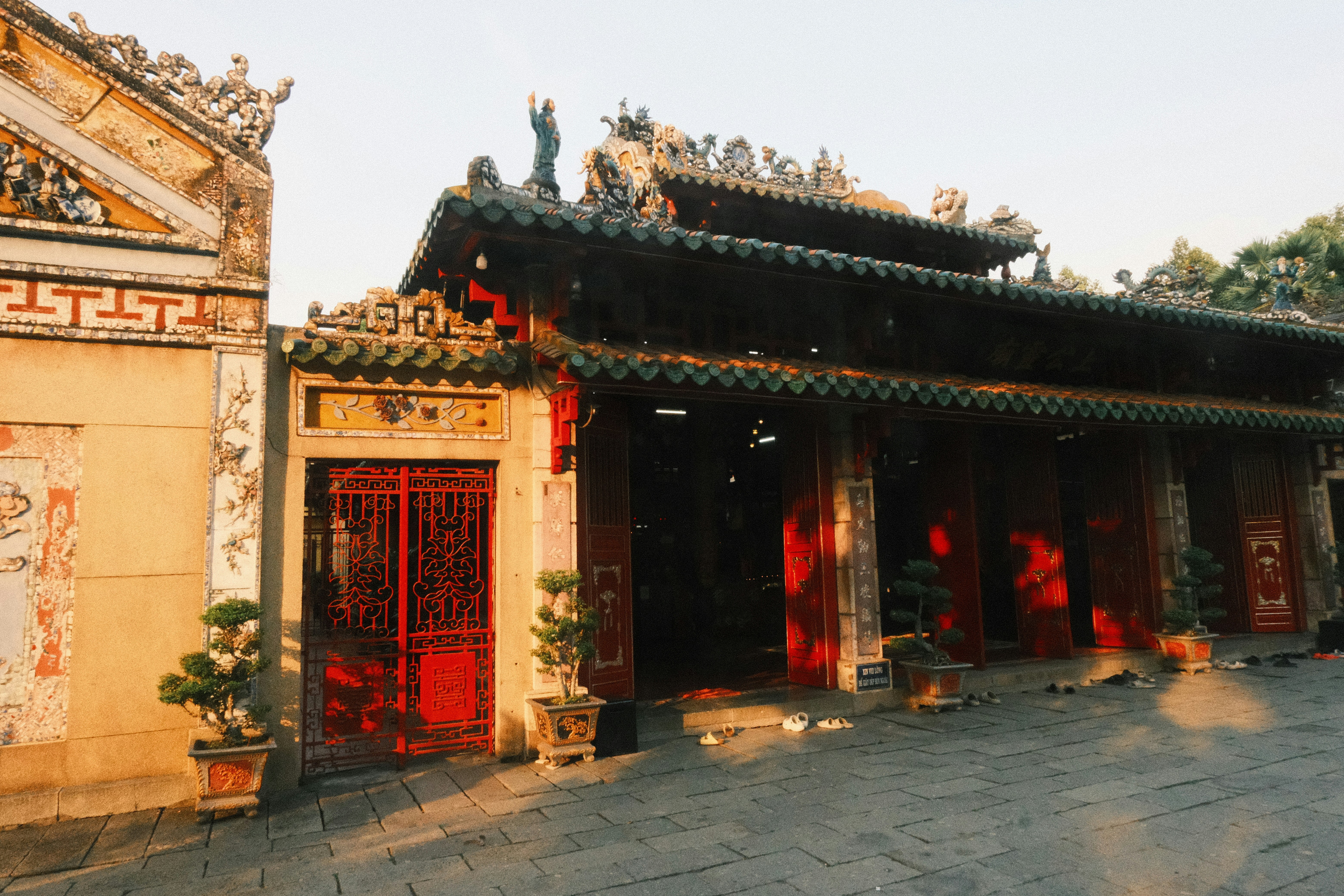 Ornate asian temple entrance with red gates in warm light.