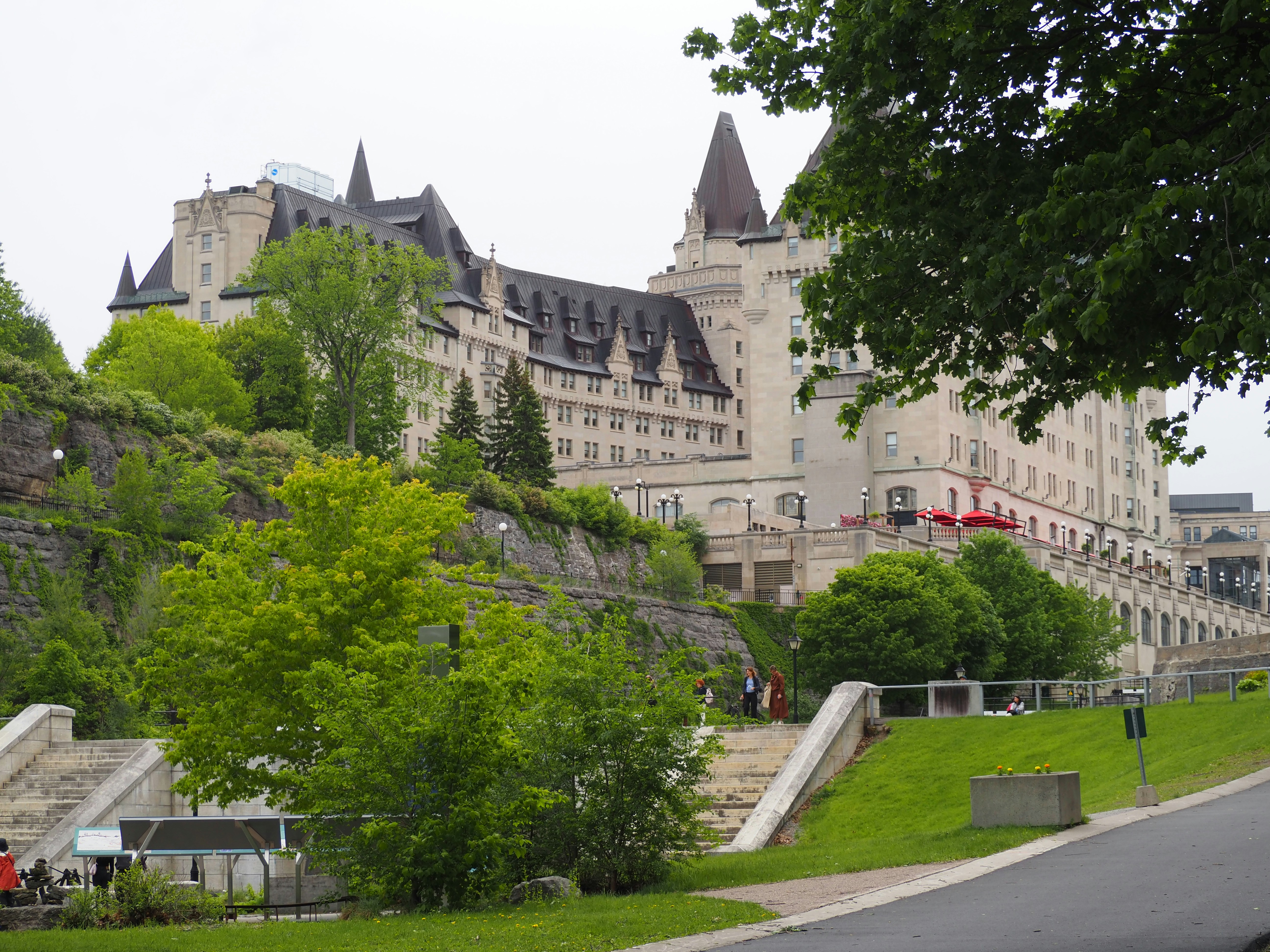 Grand hotel building on a green hill with trees.