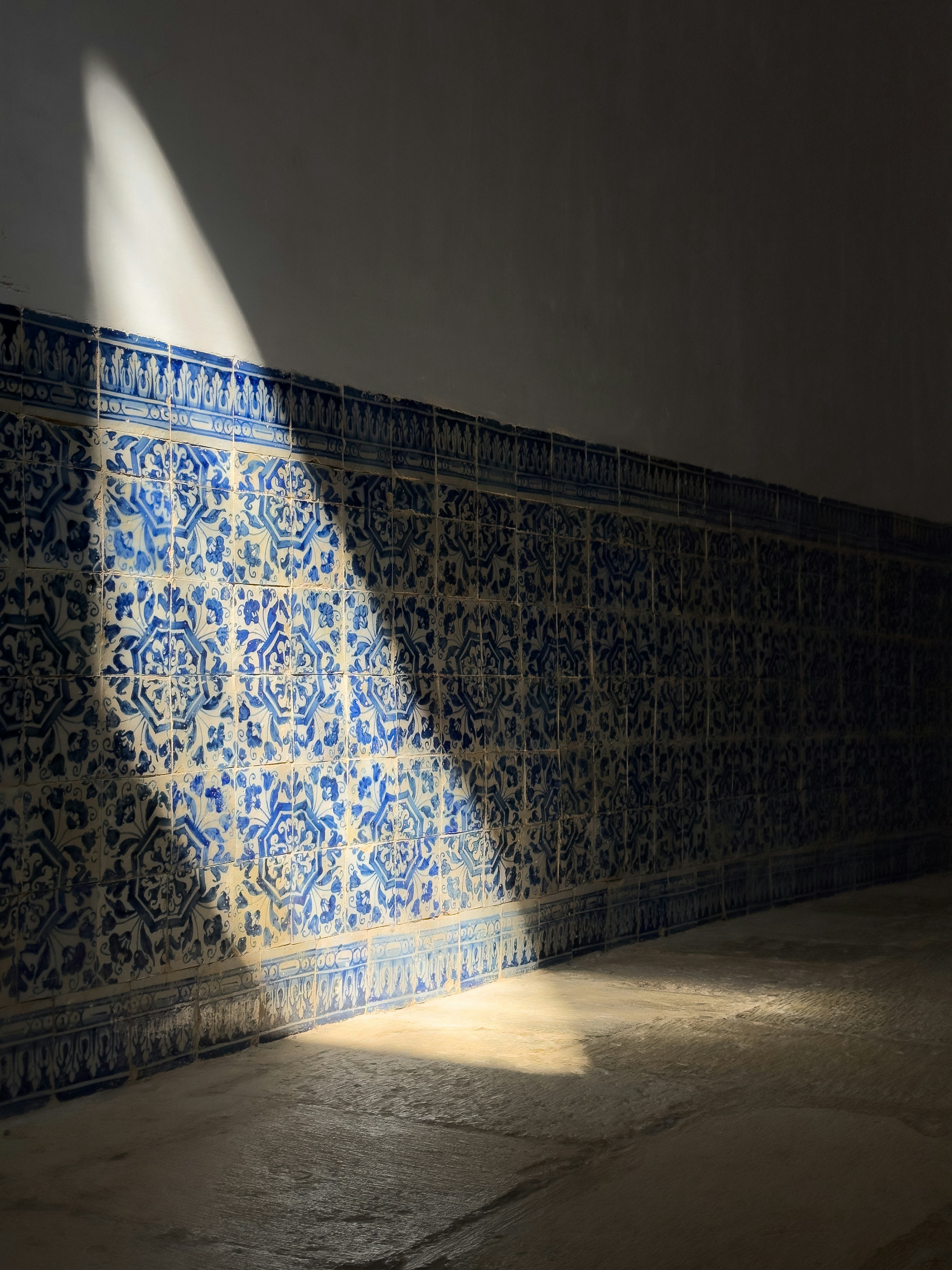 Sunlight on a wall of blue and white azulejo tiles
