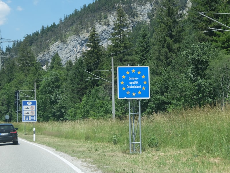 European union border sign beside a mountain road.