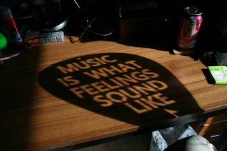 Shadowed quote 'music is what feelings sound like' on desk.