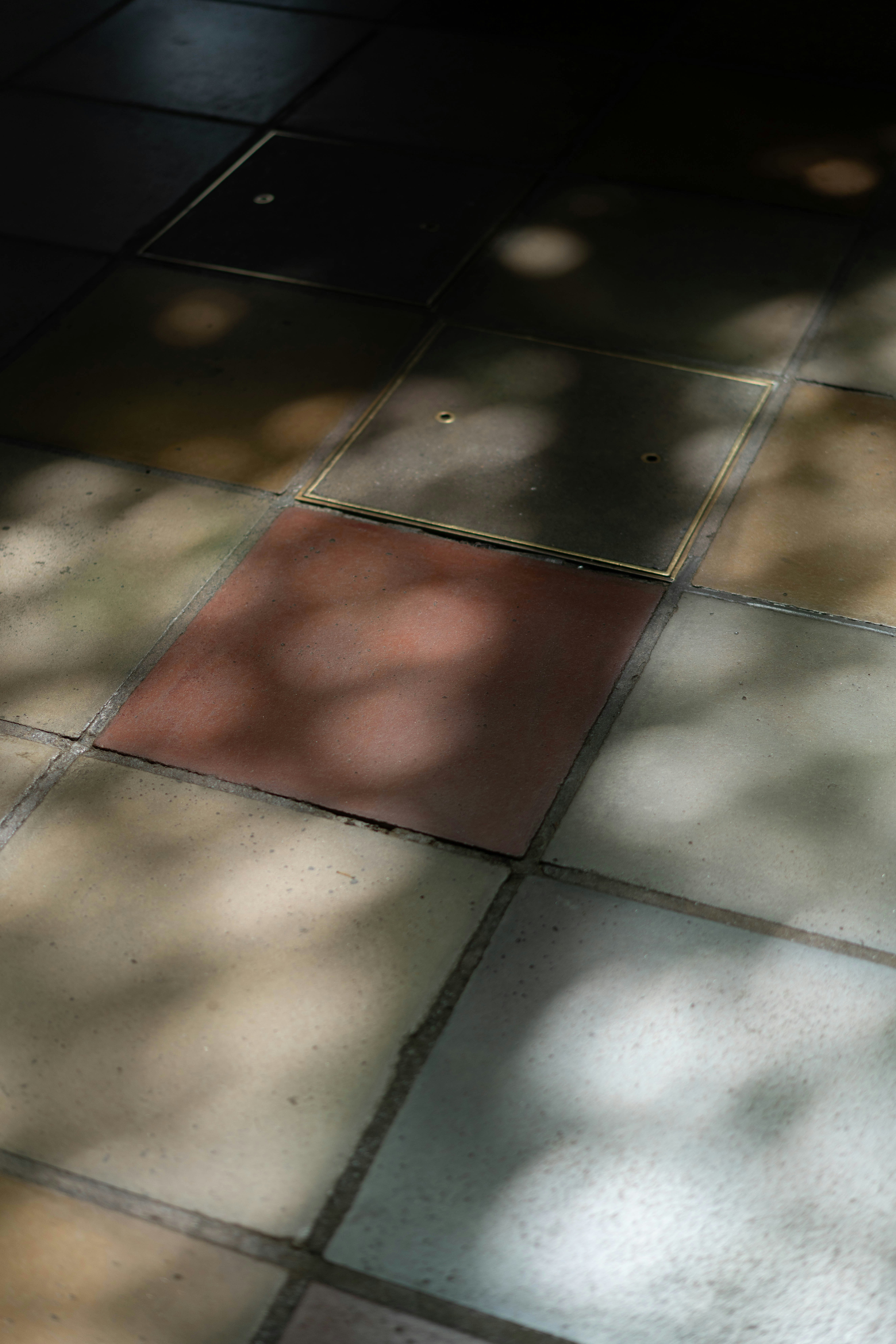 Chão colorido de azulejo com luz do sol e sombras salpicadas