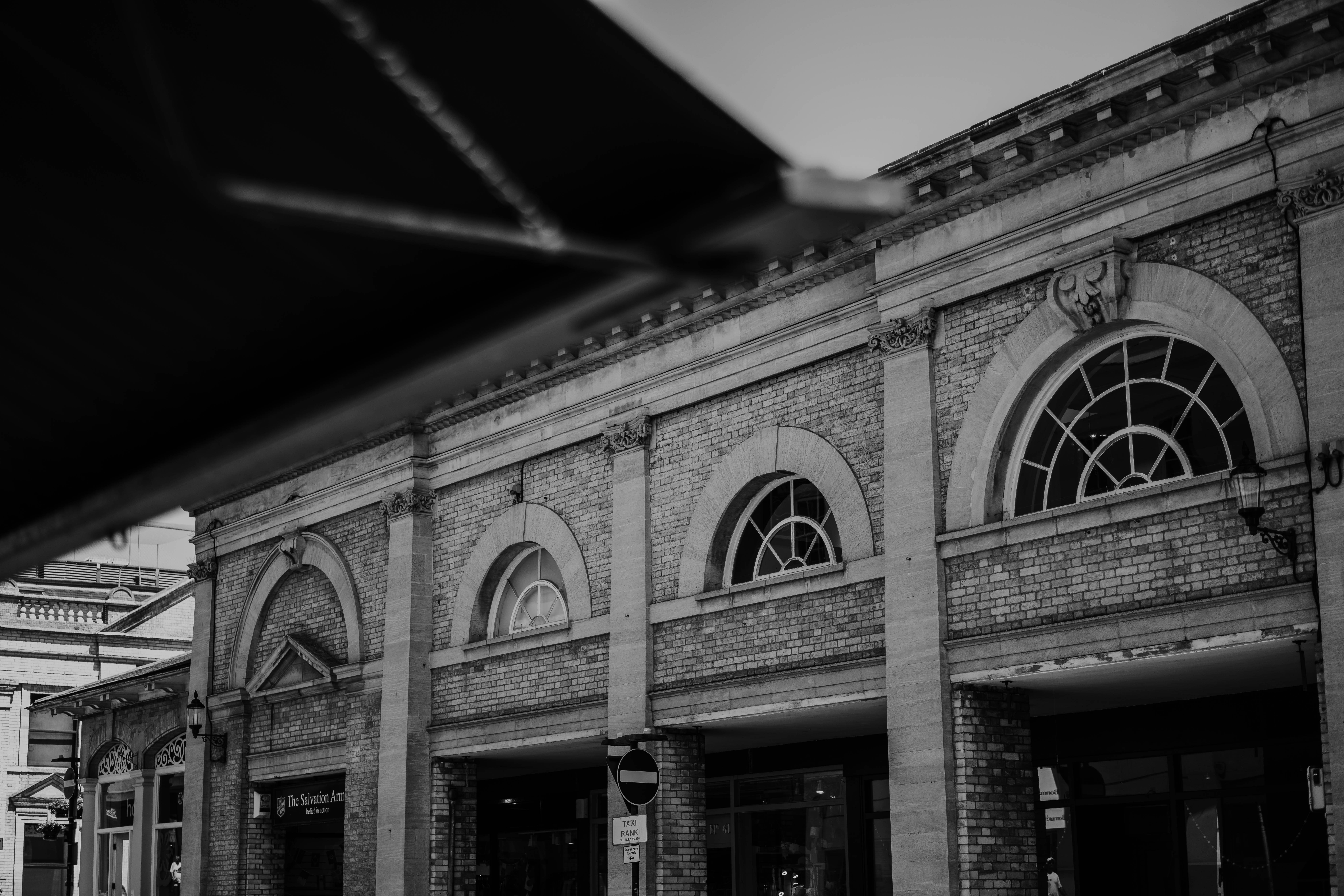 Black and white brick building with arched windows.