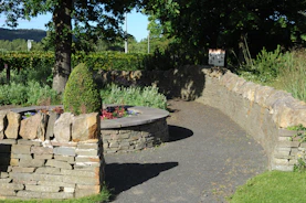 Outdoor memorial with stone walls and a winding path
