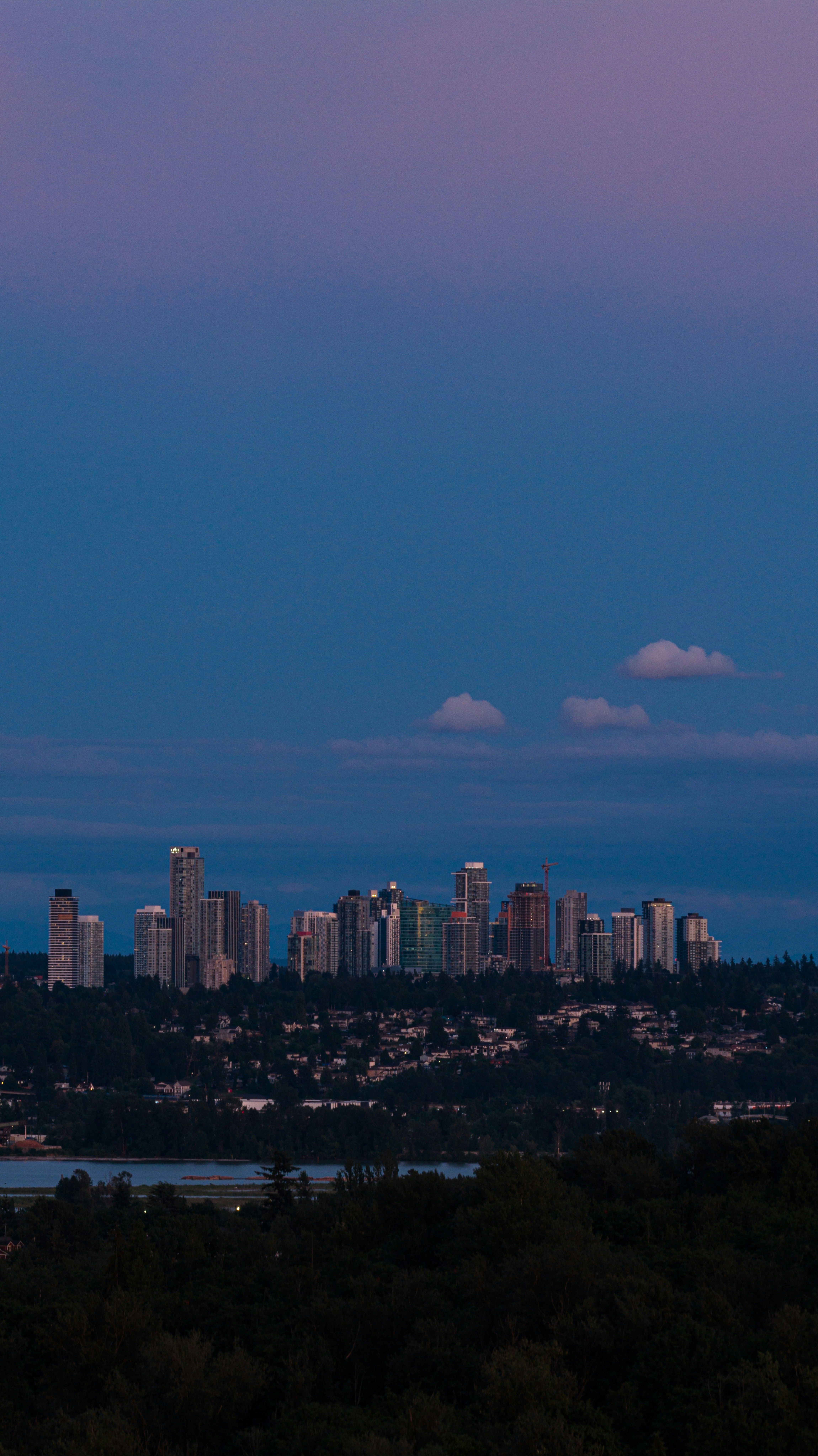 City skyline at twilight with a purple and blue sky.