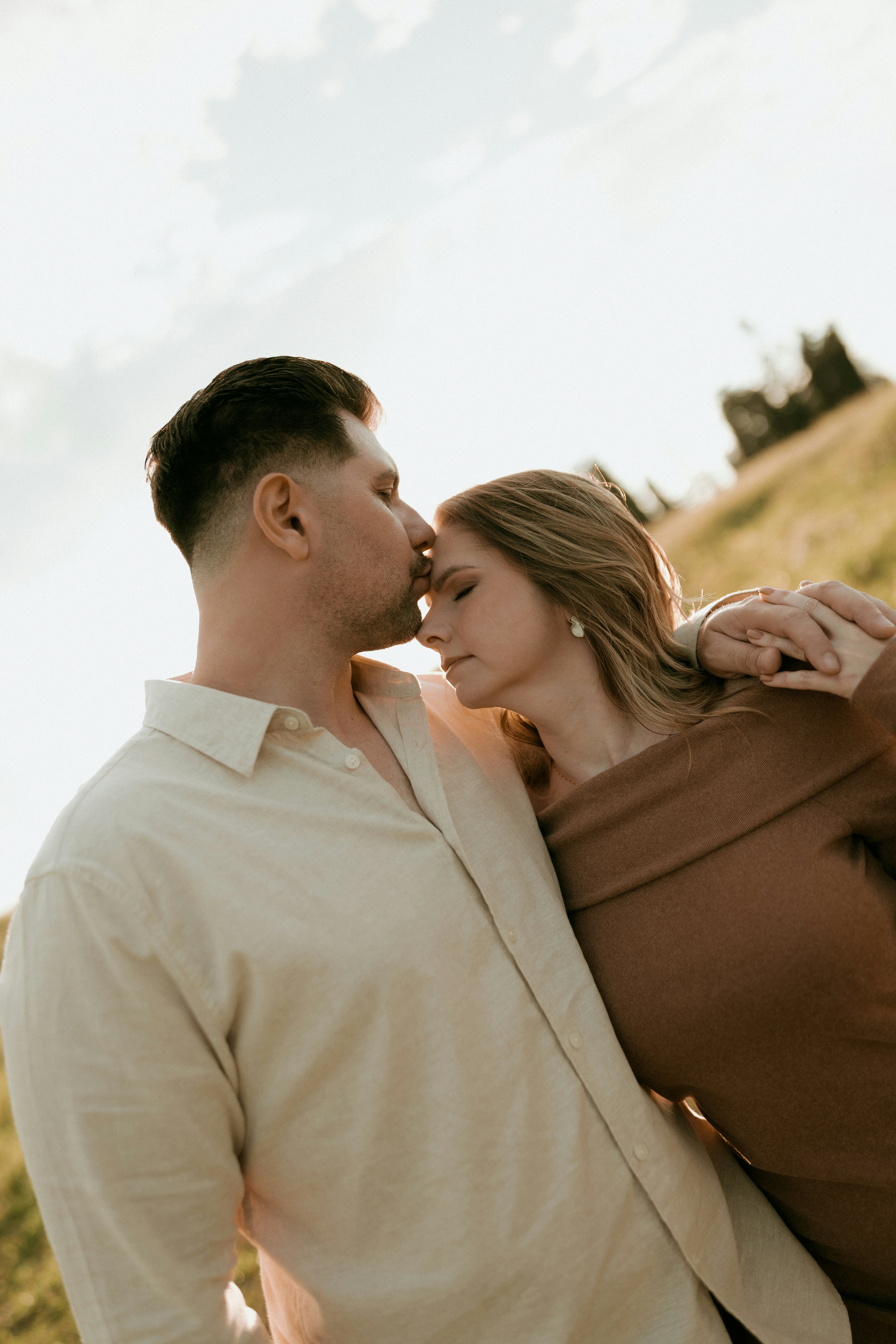 A couple embracing tenderly in the warm light of sunset
