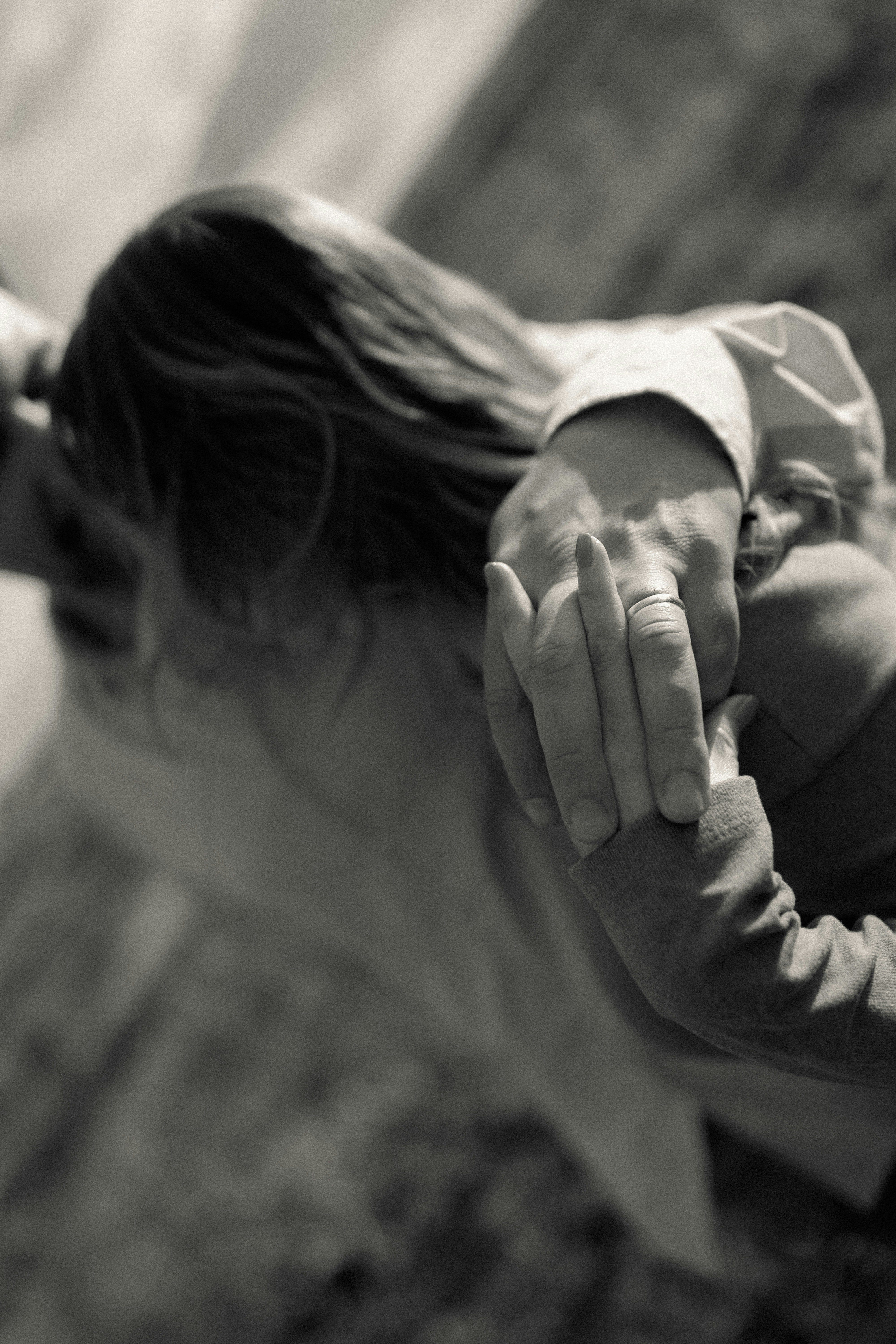 Two people embracing, hands clasped, in black and white.