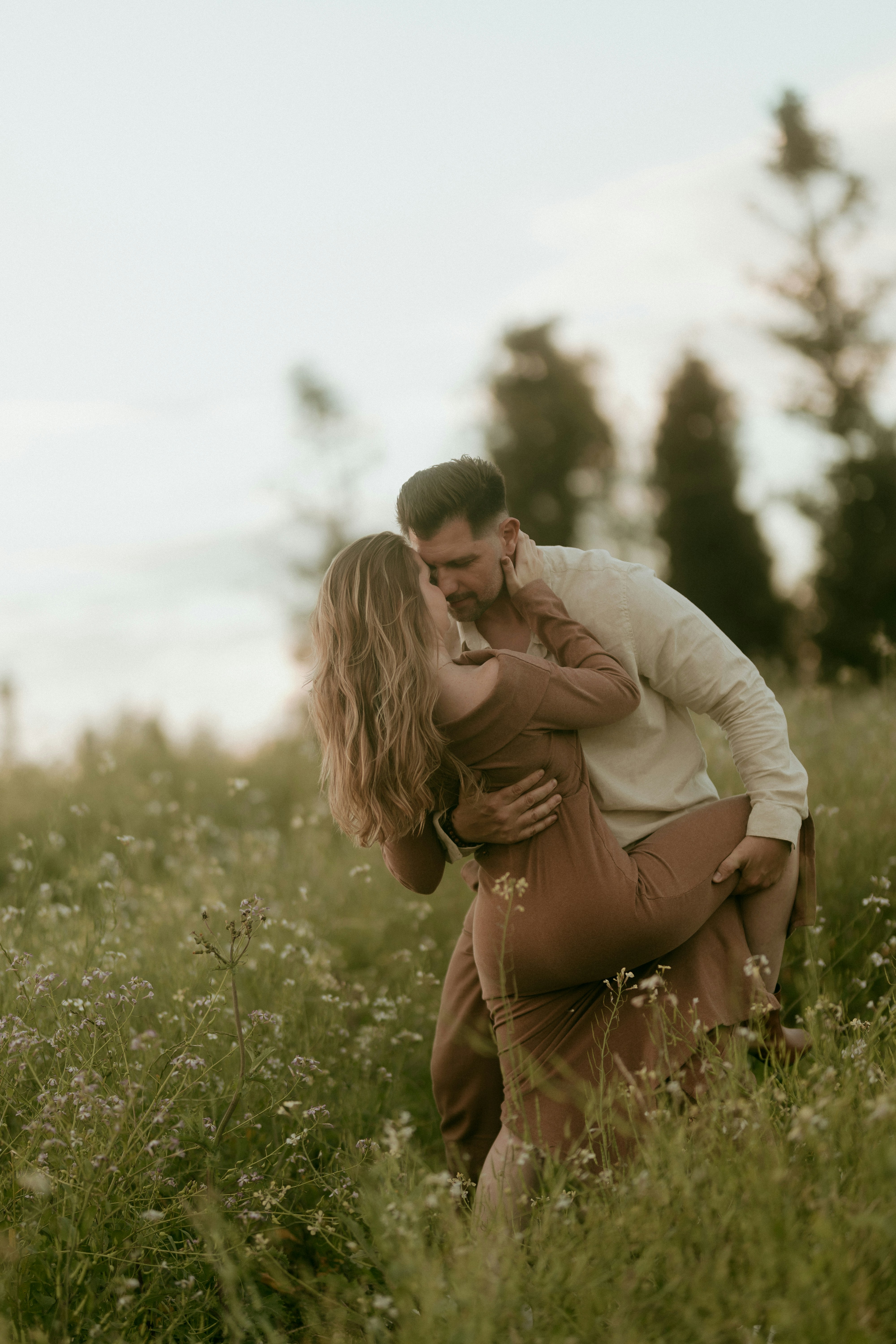 Couple kissing in a field of wildflowers