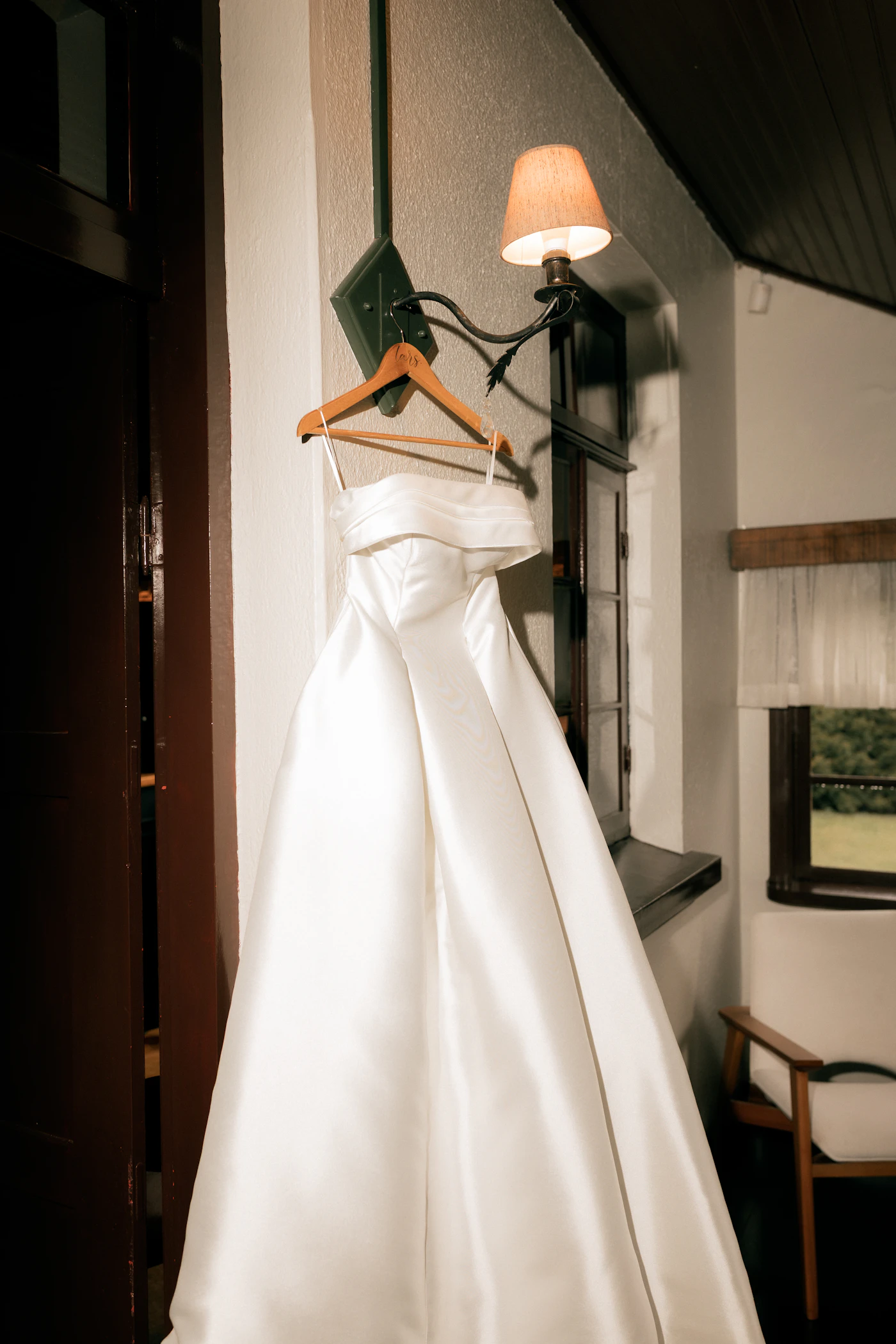 How to remove stains from a satin wedding gown — A bride examining the hem of her satin wedding gown for potential stains.