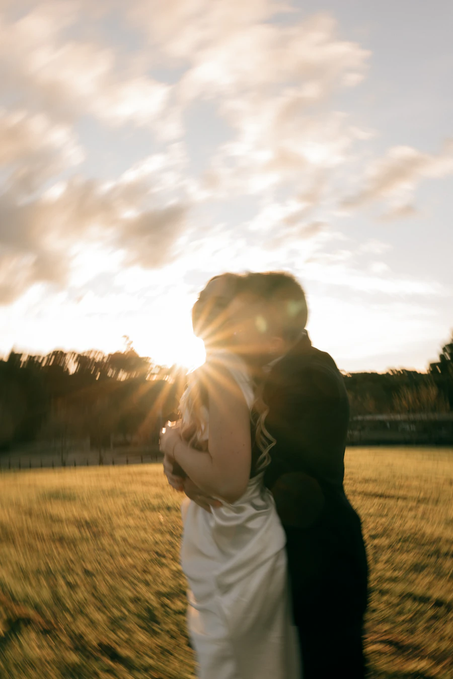 Couple embracing against a sun flare