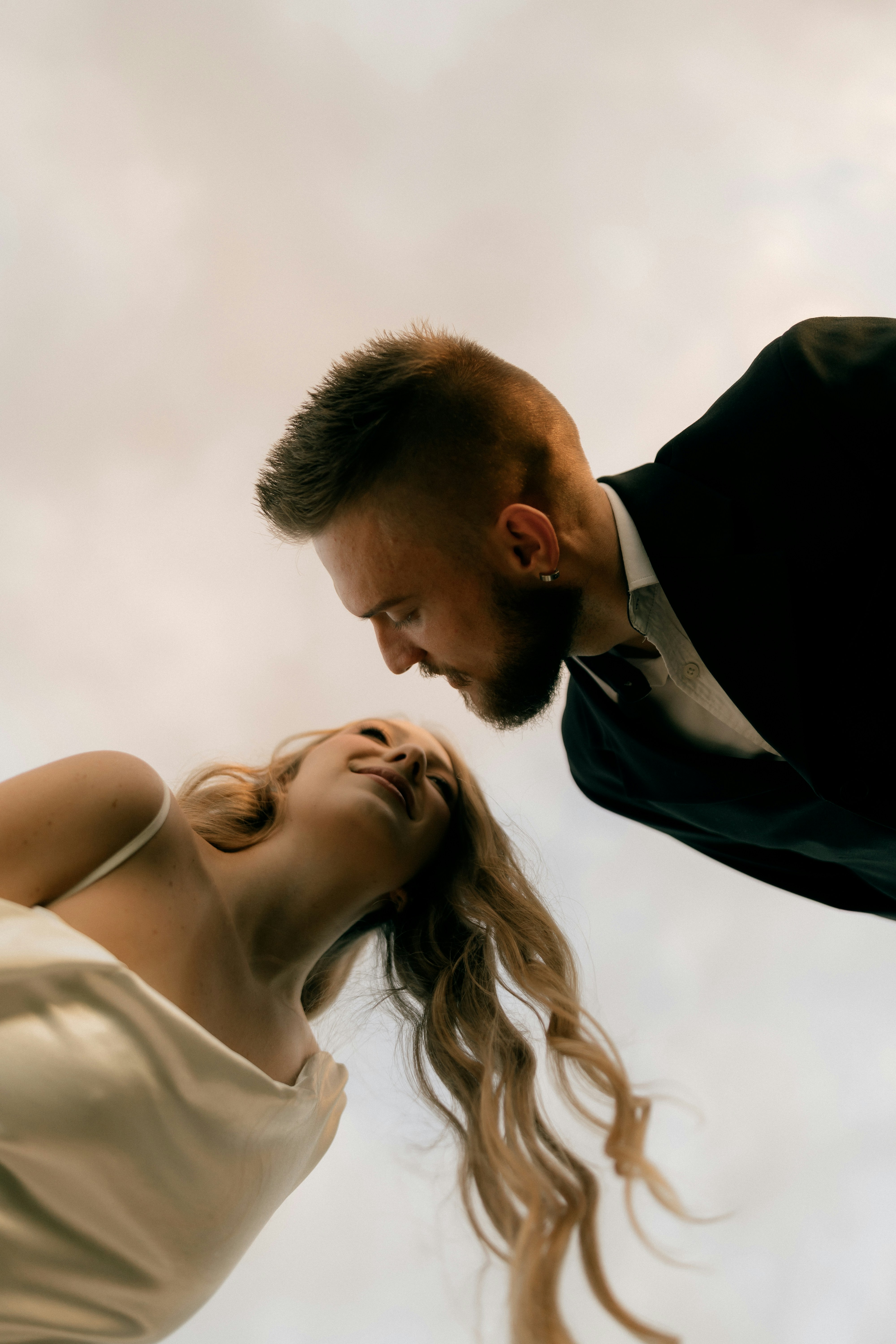 Uomo in giacca e giacca che guarda una donna in abito bianco.