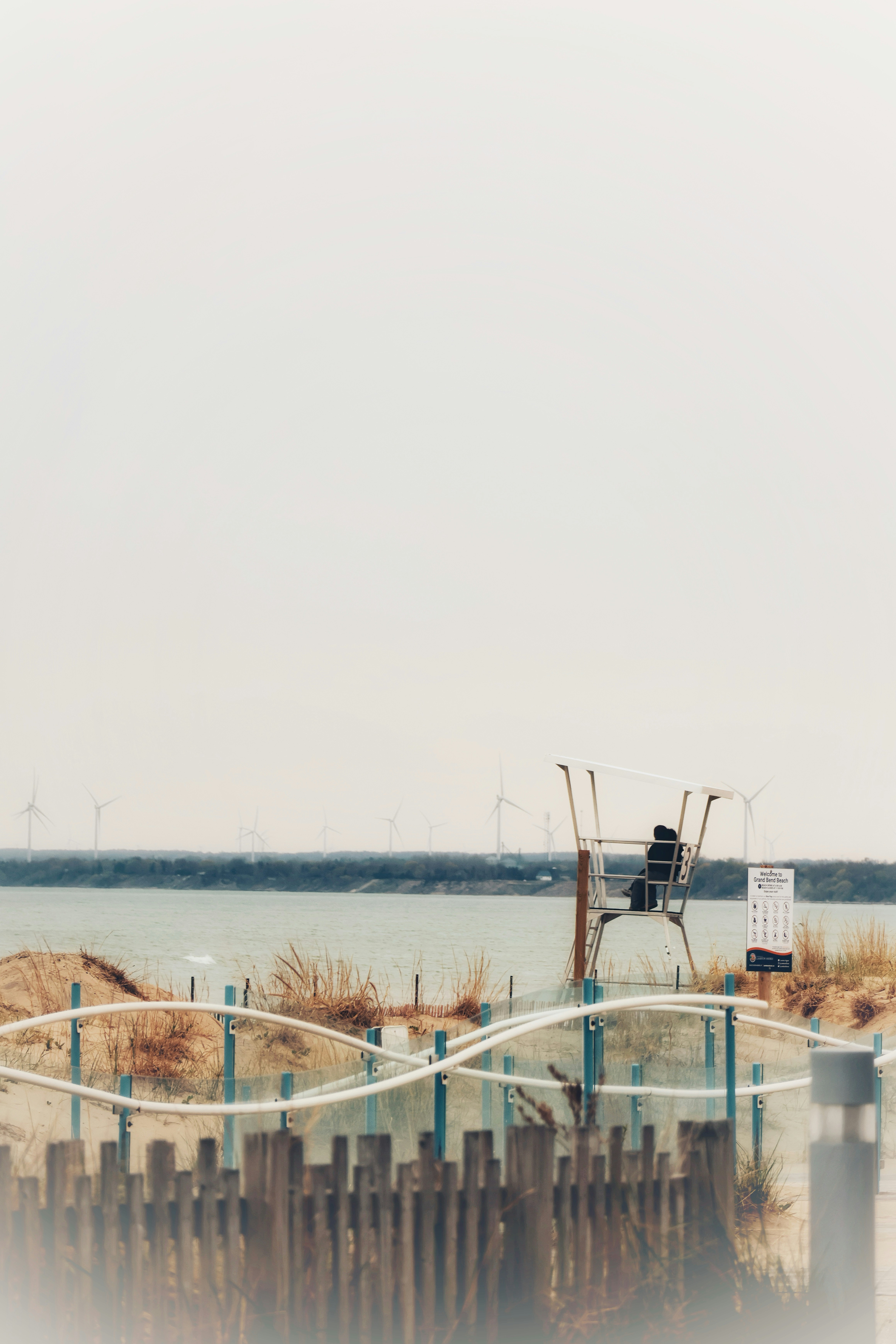Rettungsschwimmerstuhl an einem Sandstrand mit Windturbinen