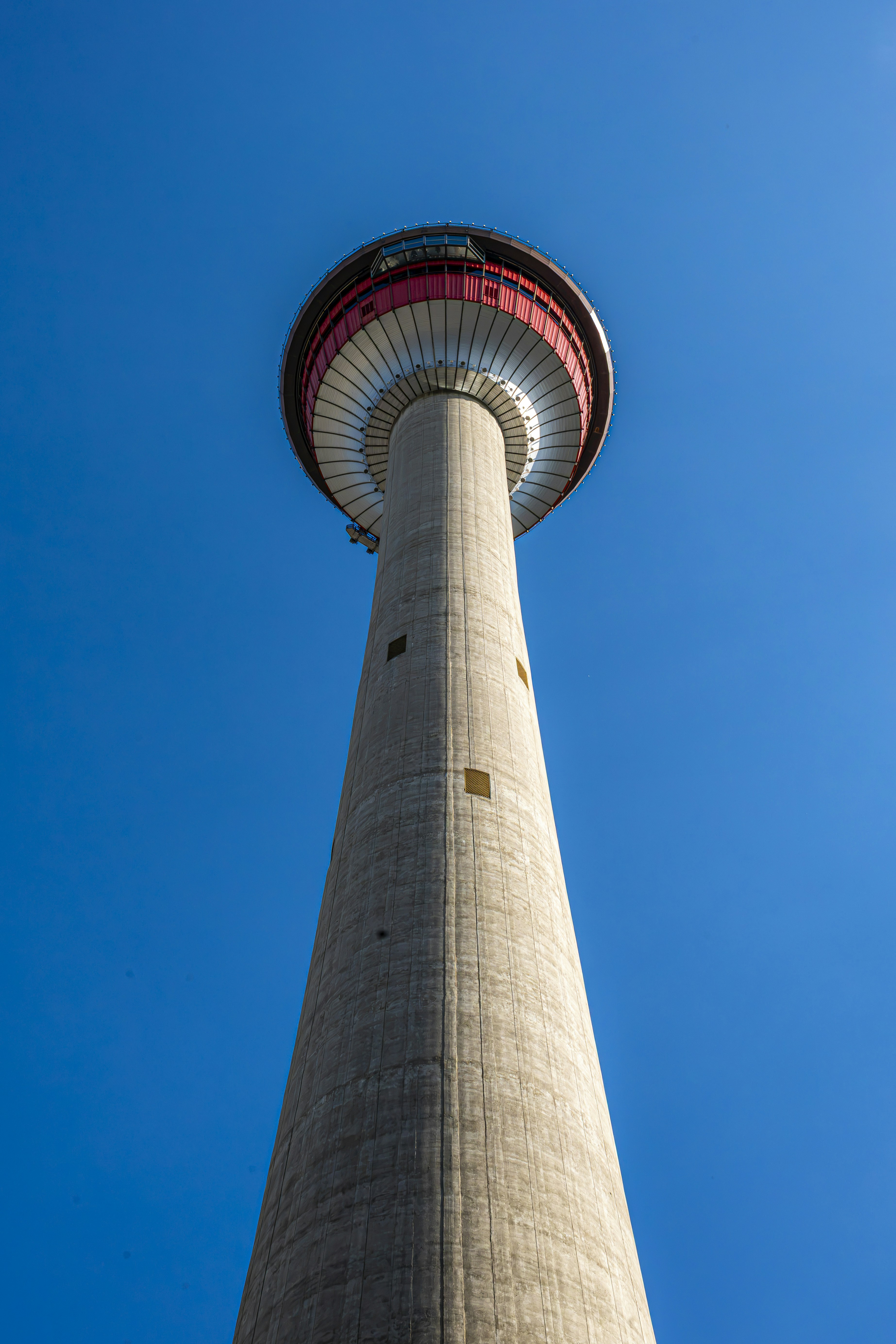 Tall concrete tower with red observation deck against blue sky