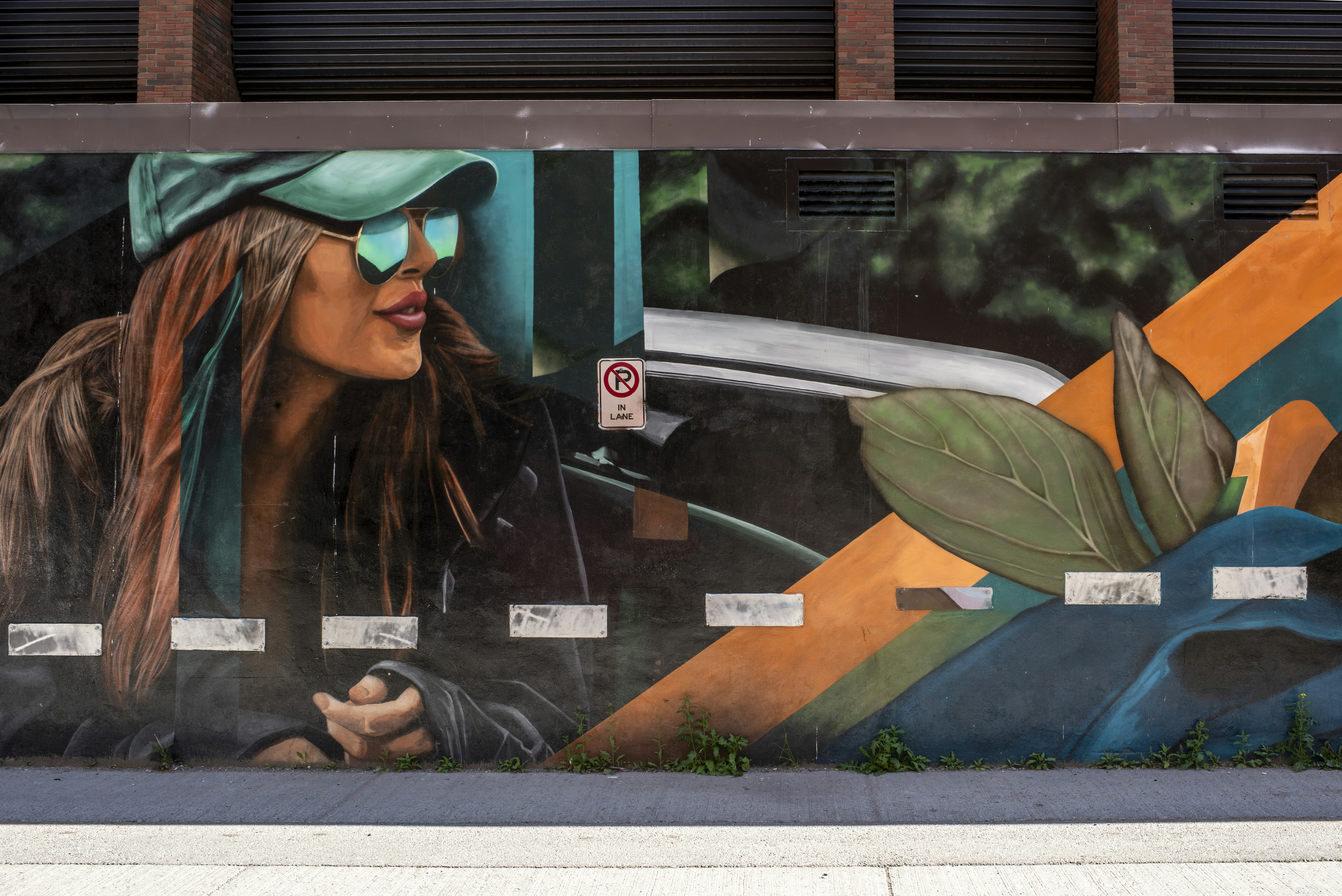 Urban mural of a woman in a hat and sunglasses