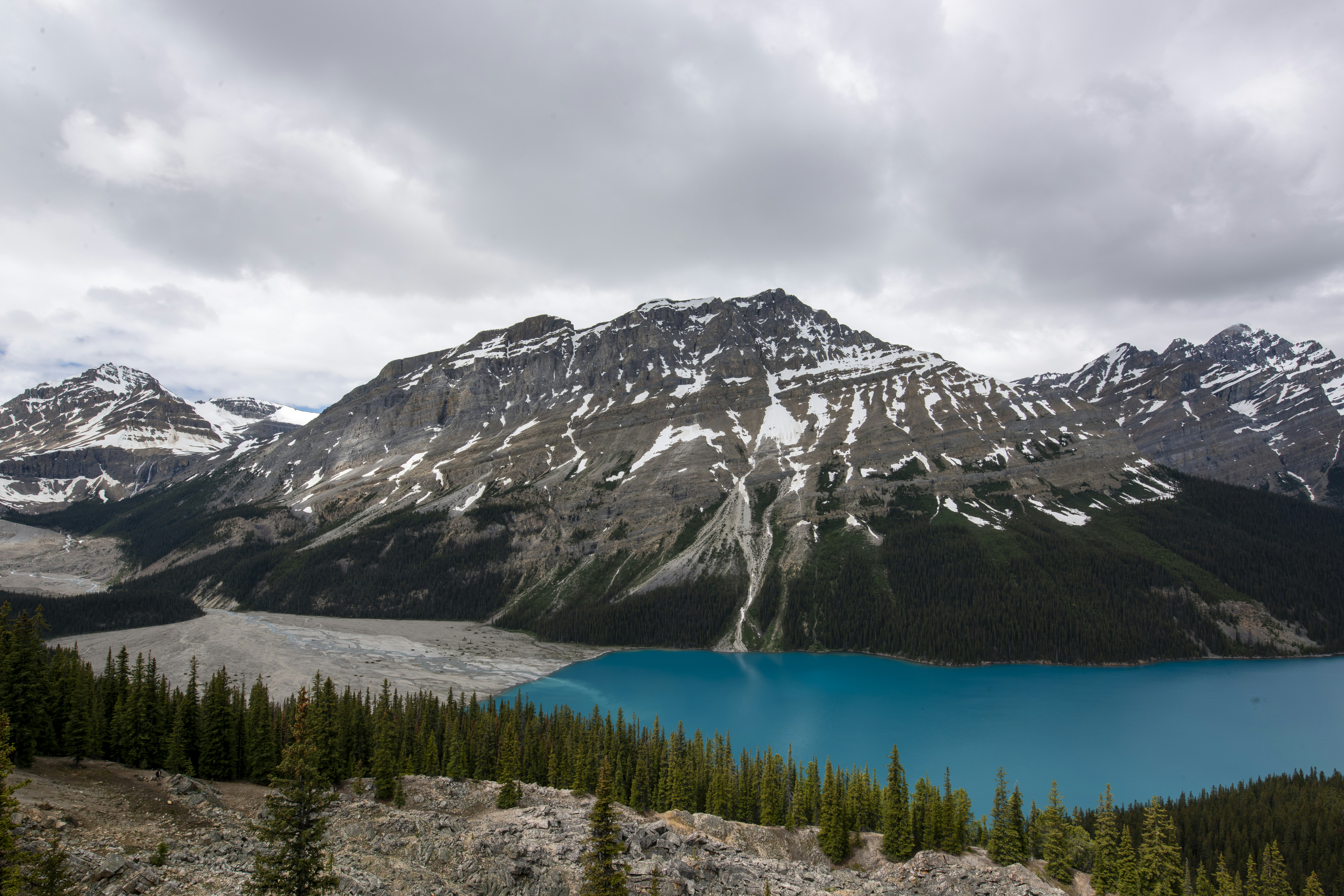 Turquoise lake nestled among snow-capped mountains and green forests