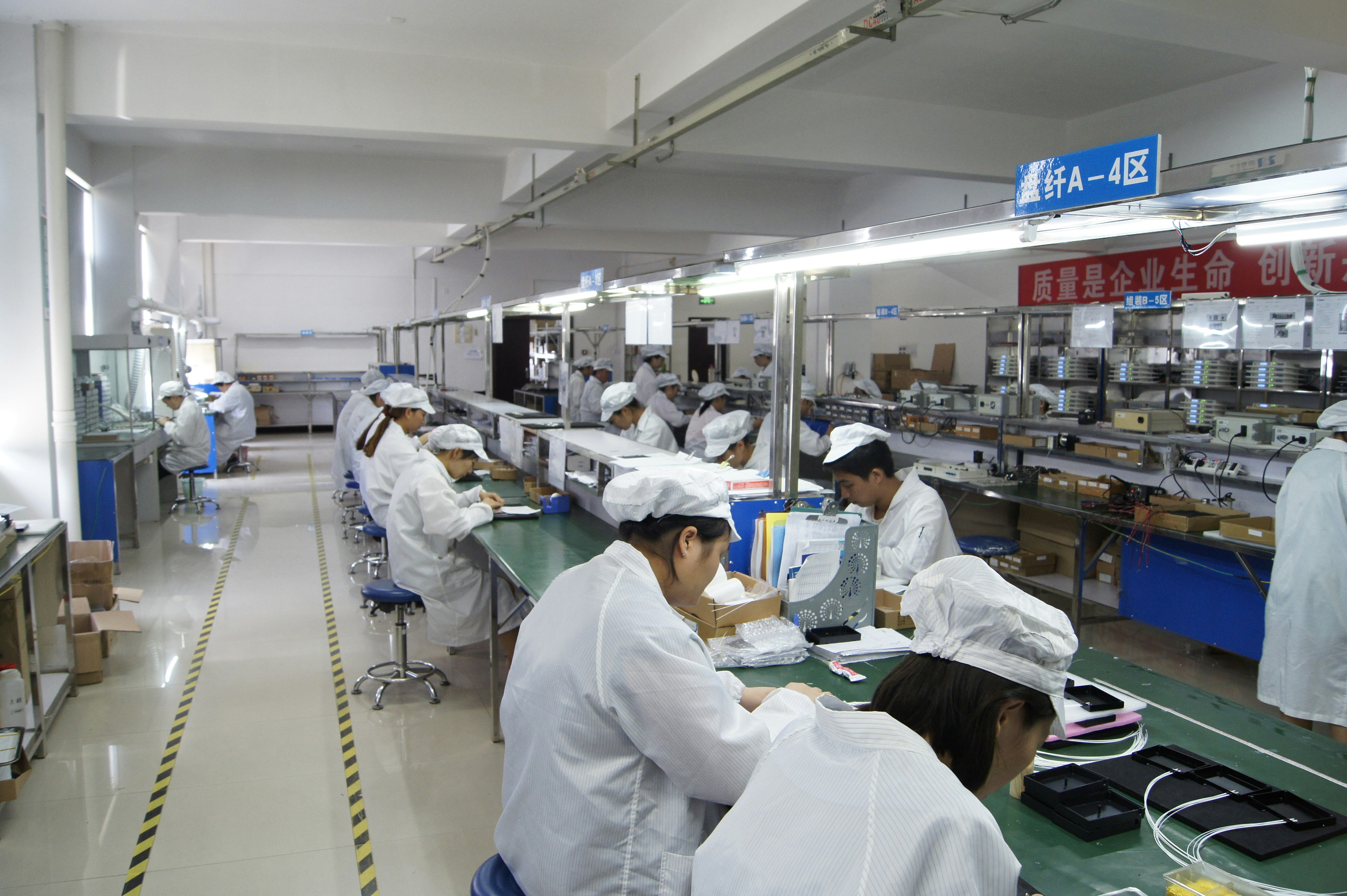 AI需要で急回復した半導体メモリ大手キオクシア。工場で電子部品を組み立てる作業員の姿。