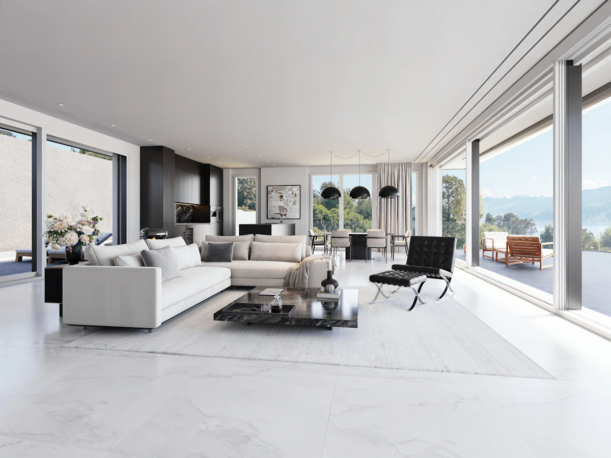 Living room with floor to ceiling windows overlooking a lake and mountains