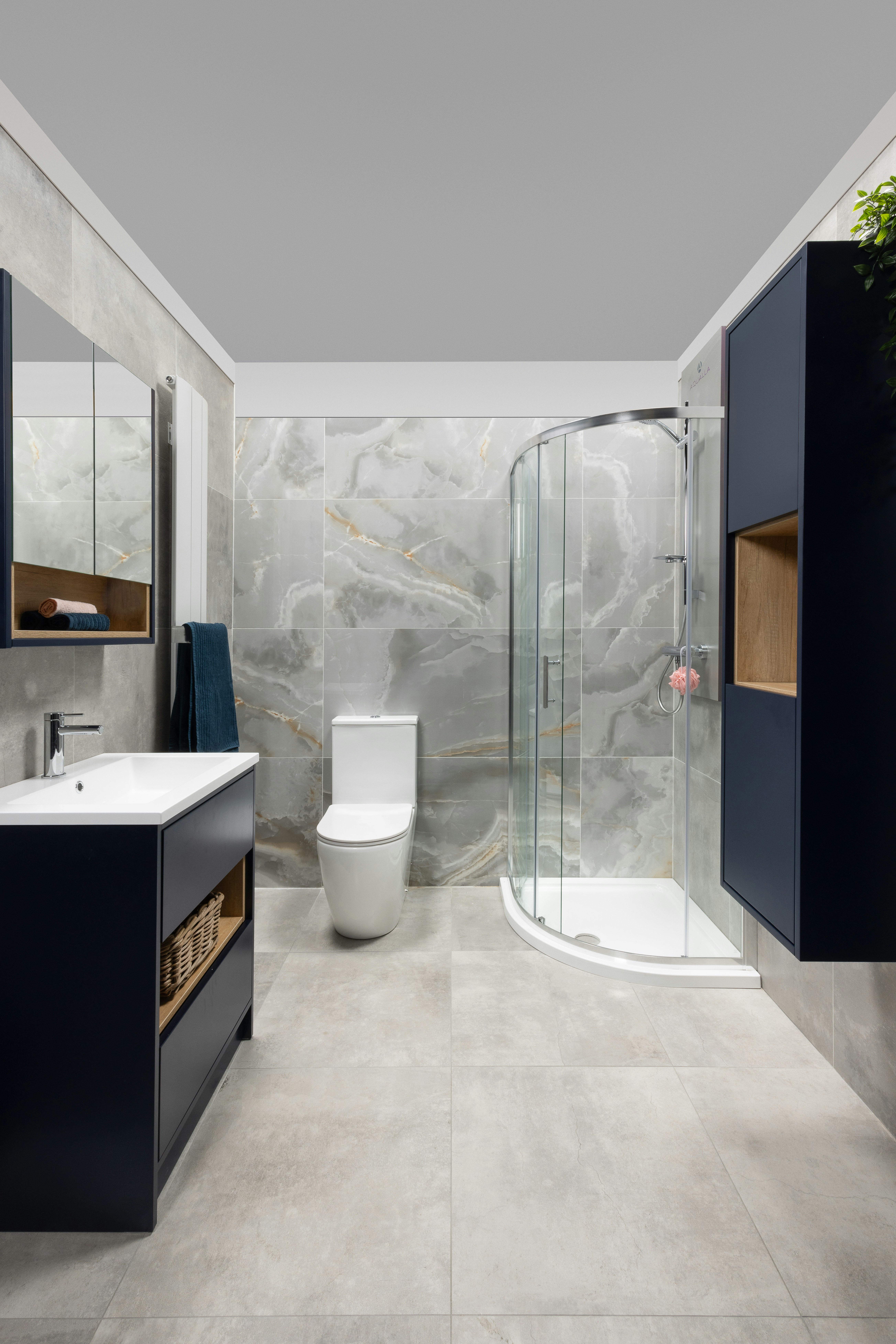 Baño moderno y elegante con armarios y ducha azul oscuro.