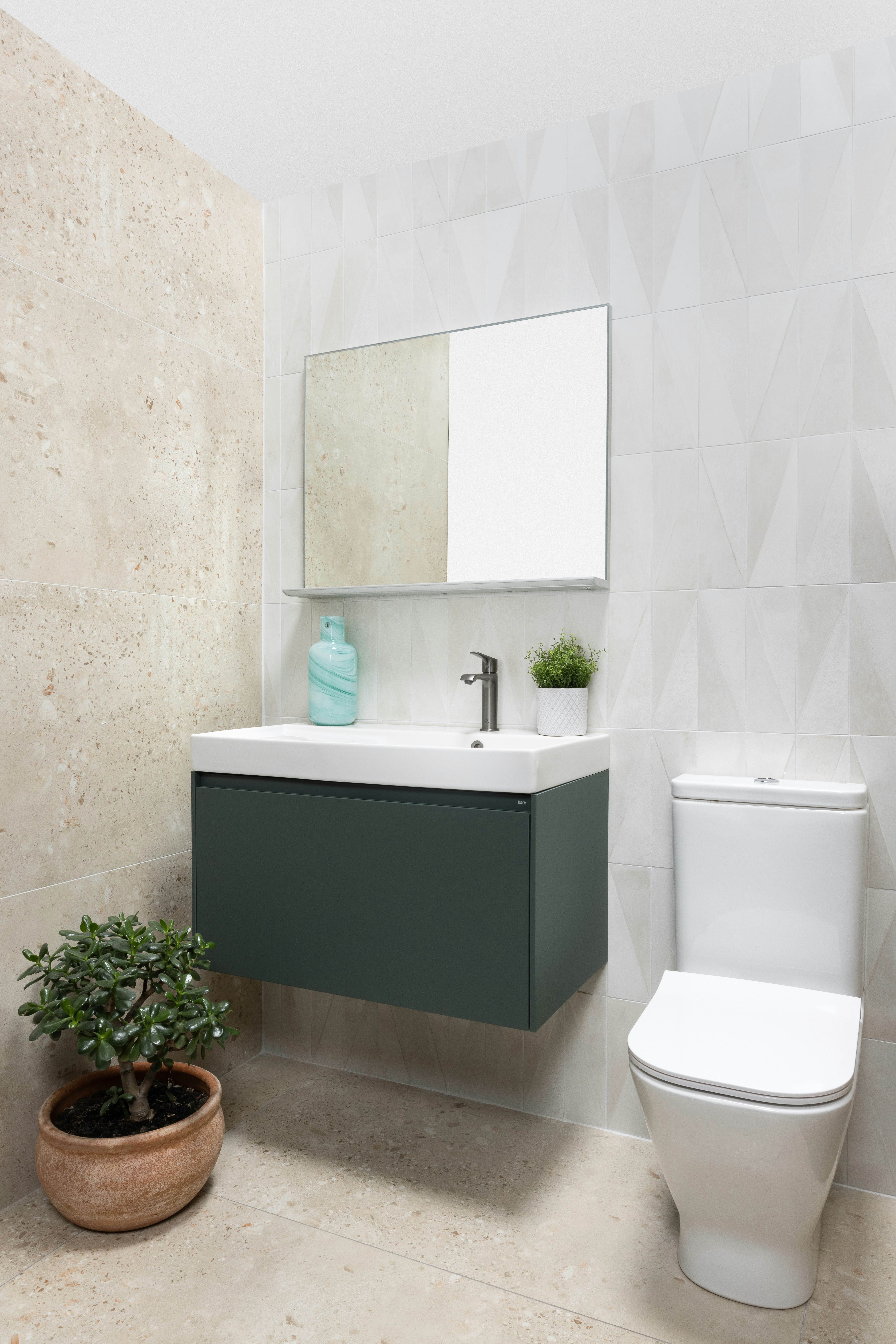 Baño moderno con tocador verde oscuro, lavabo blanco y inodoro.