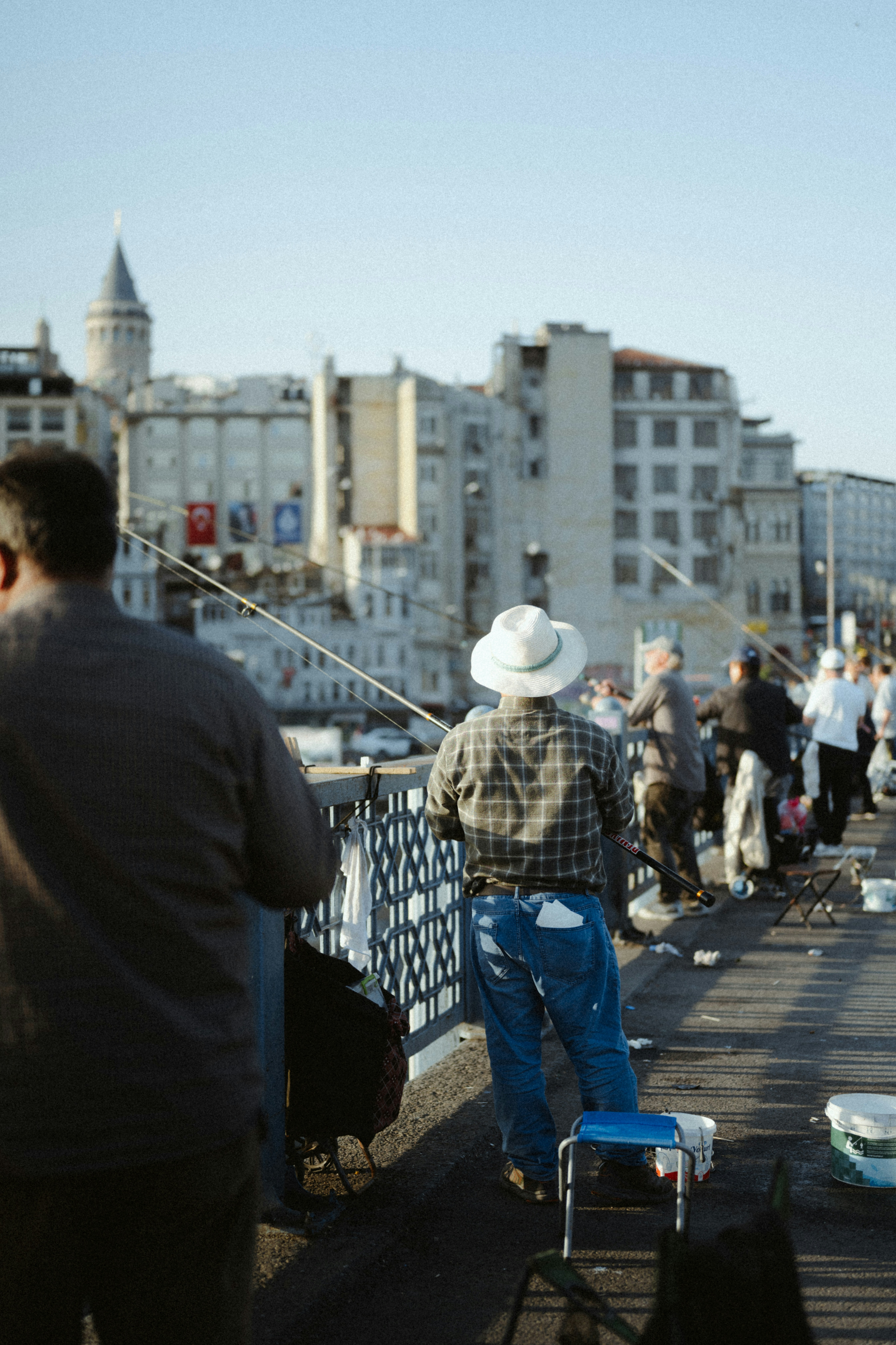 Nelayan di jembatan dengan latar belakang menara galata.