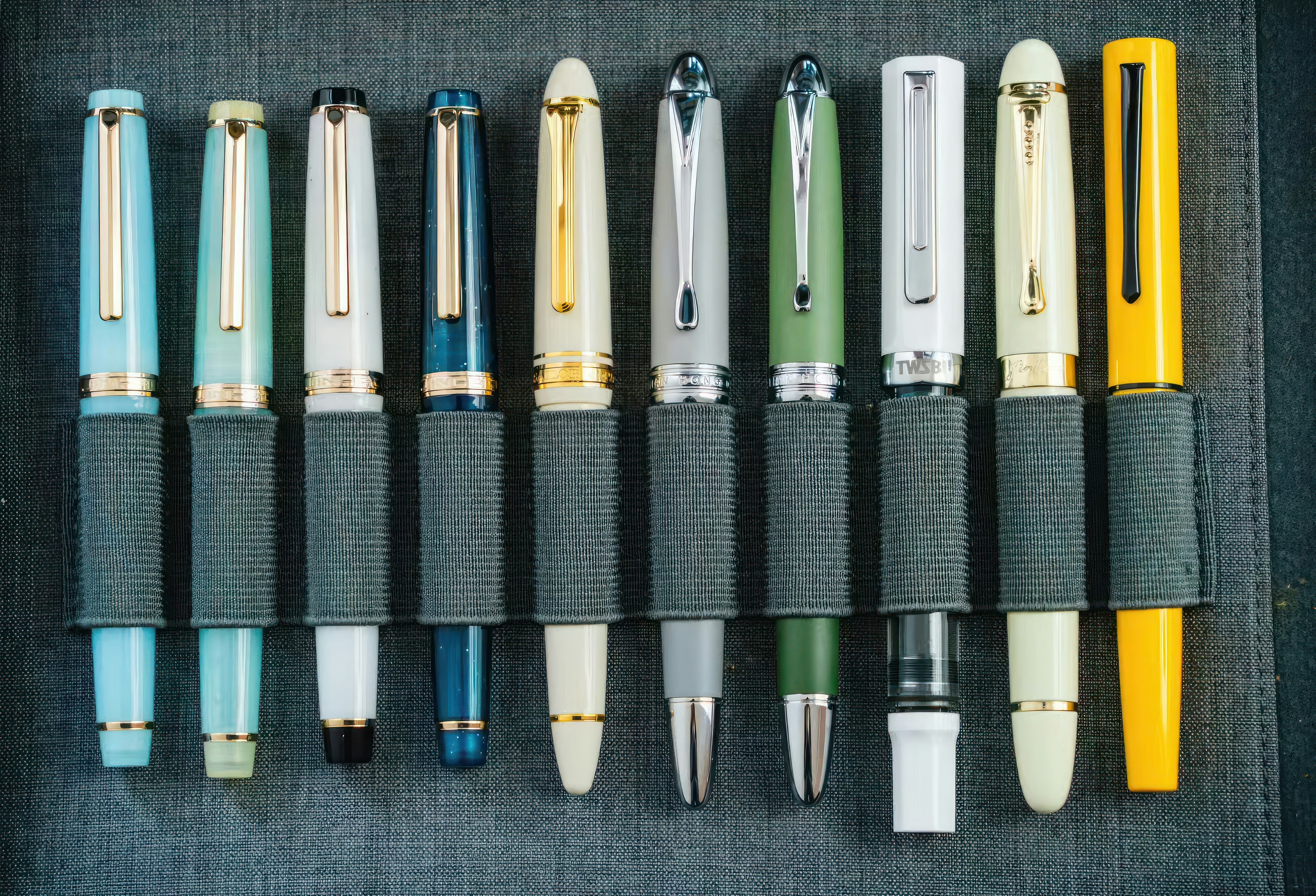 A collection of colorful fountain pens displayed in a holder