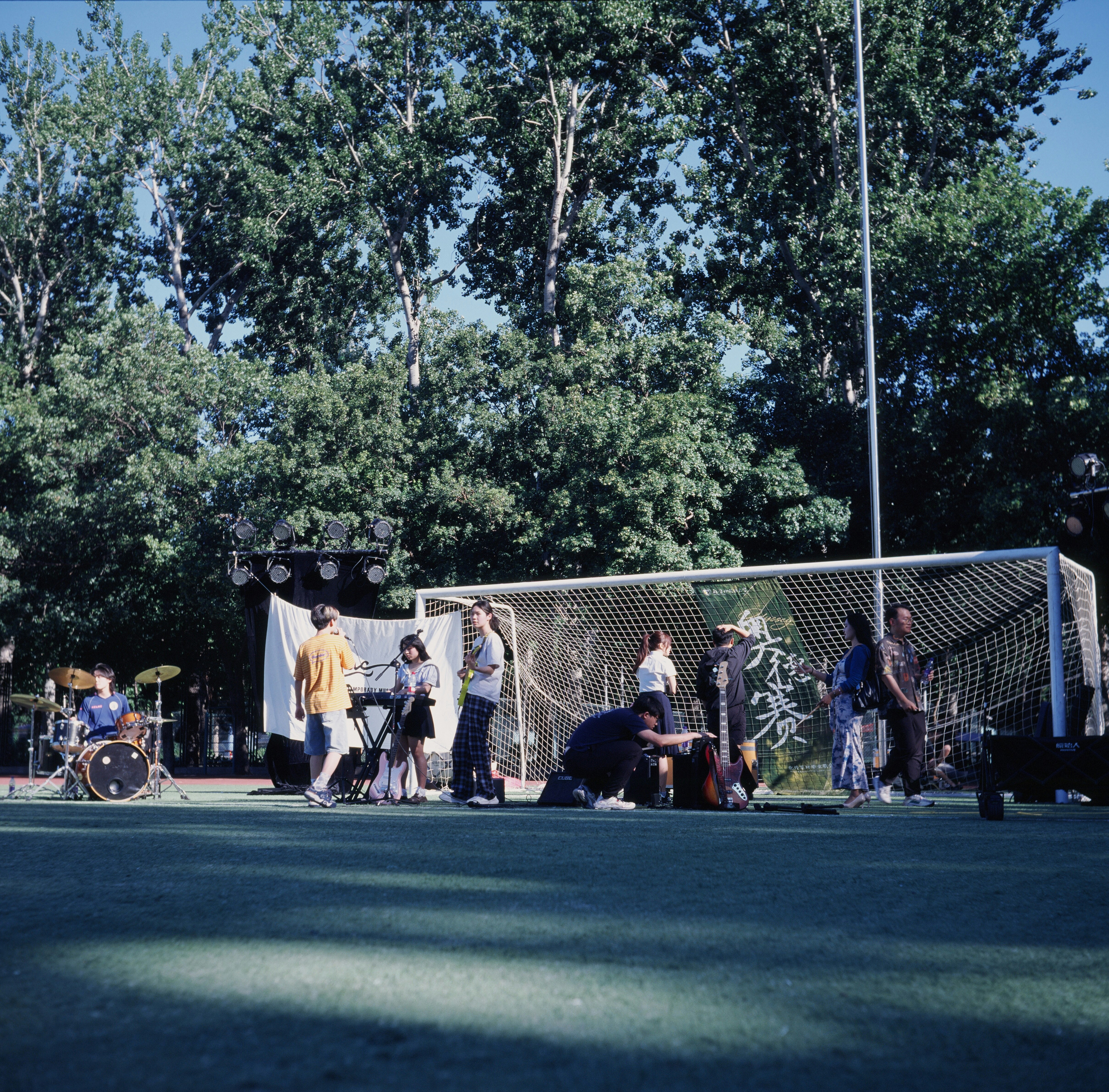 Outdoor event setup with stage, instruments, and soccer goal.