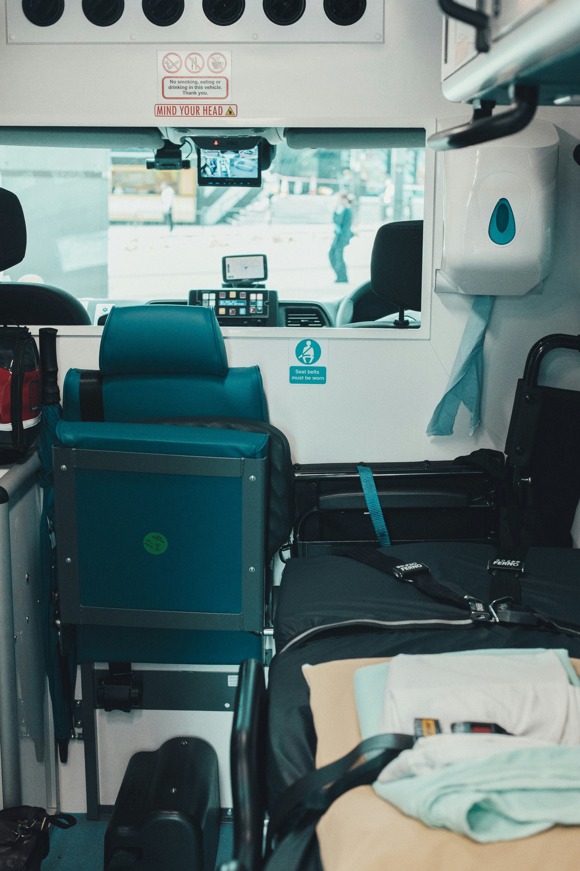 Interior view of an ambulance with a stretcher and seat.
