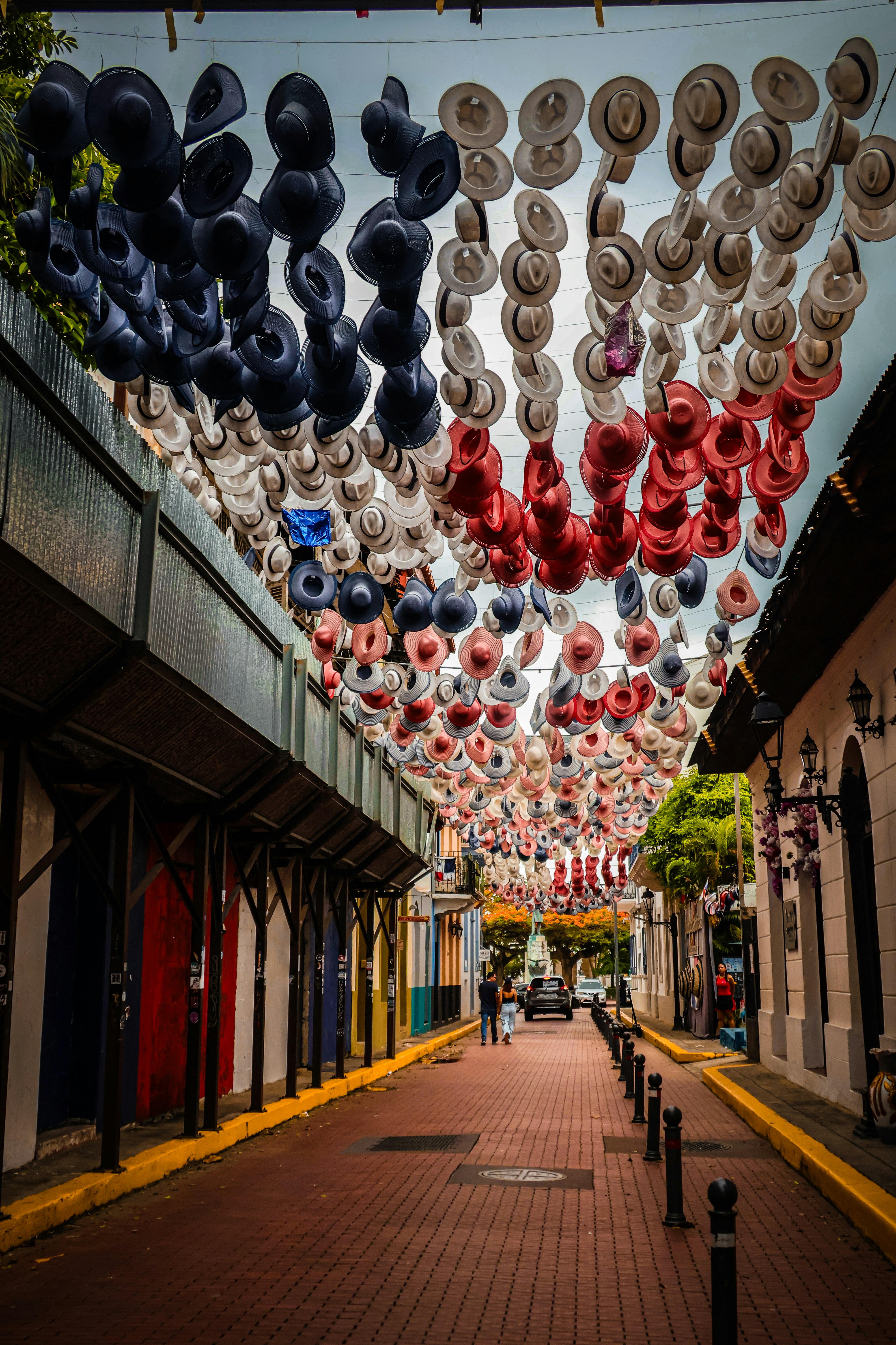 Street decorated with red, white, and blue hats overhead.
