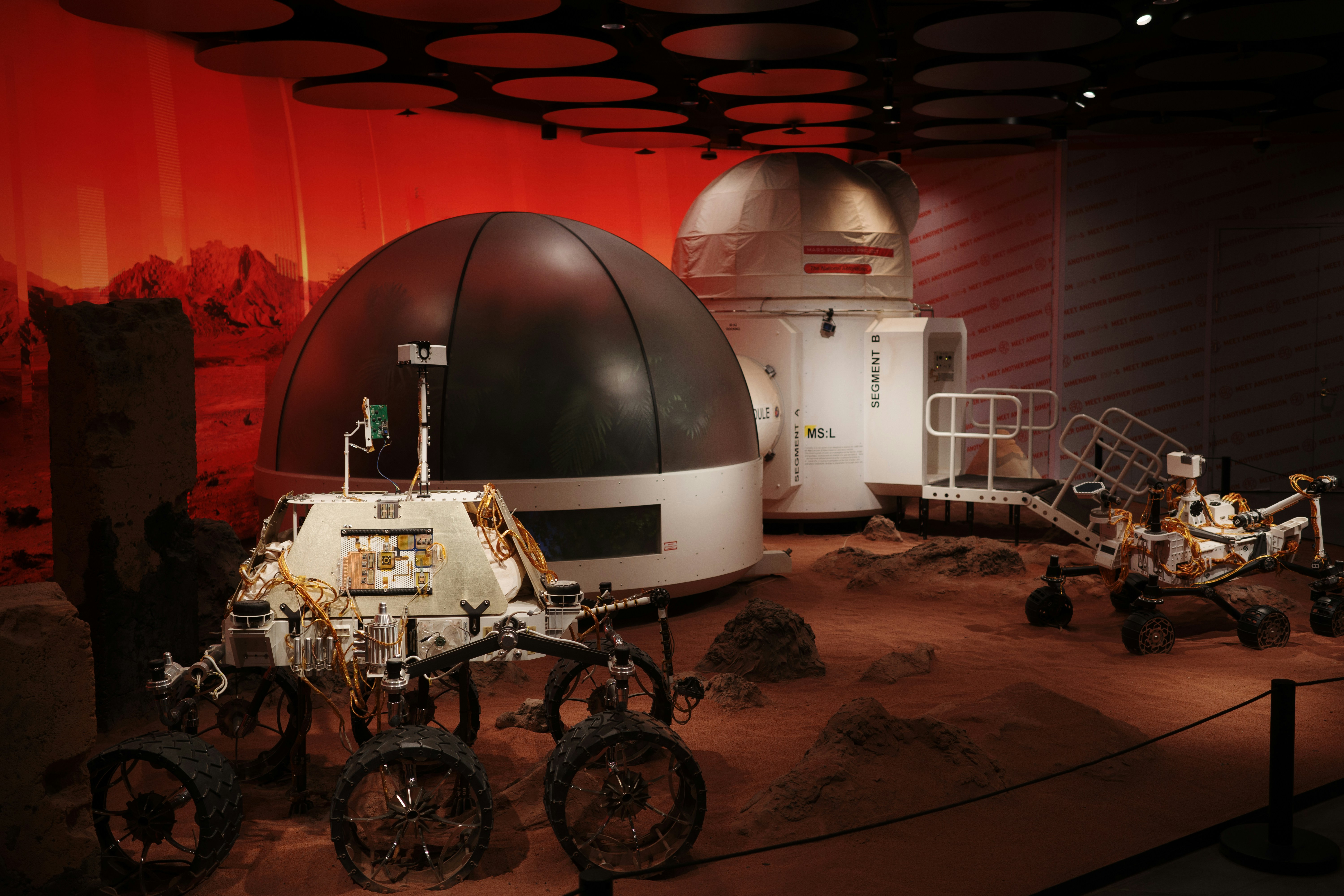 Martian rovers and habitats in a space exploration exhibit.