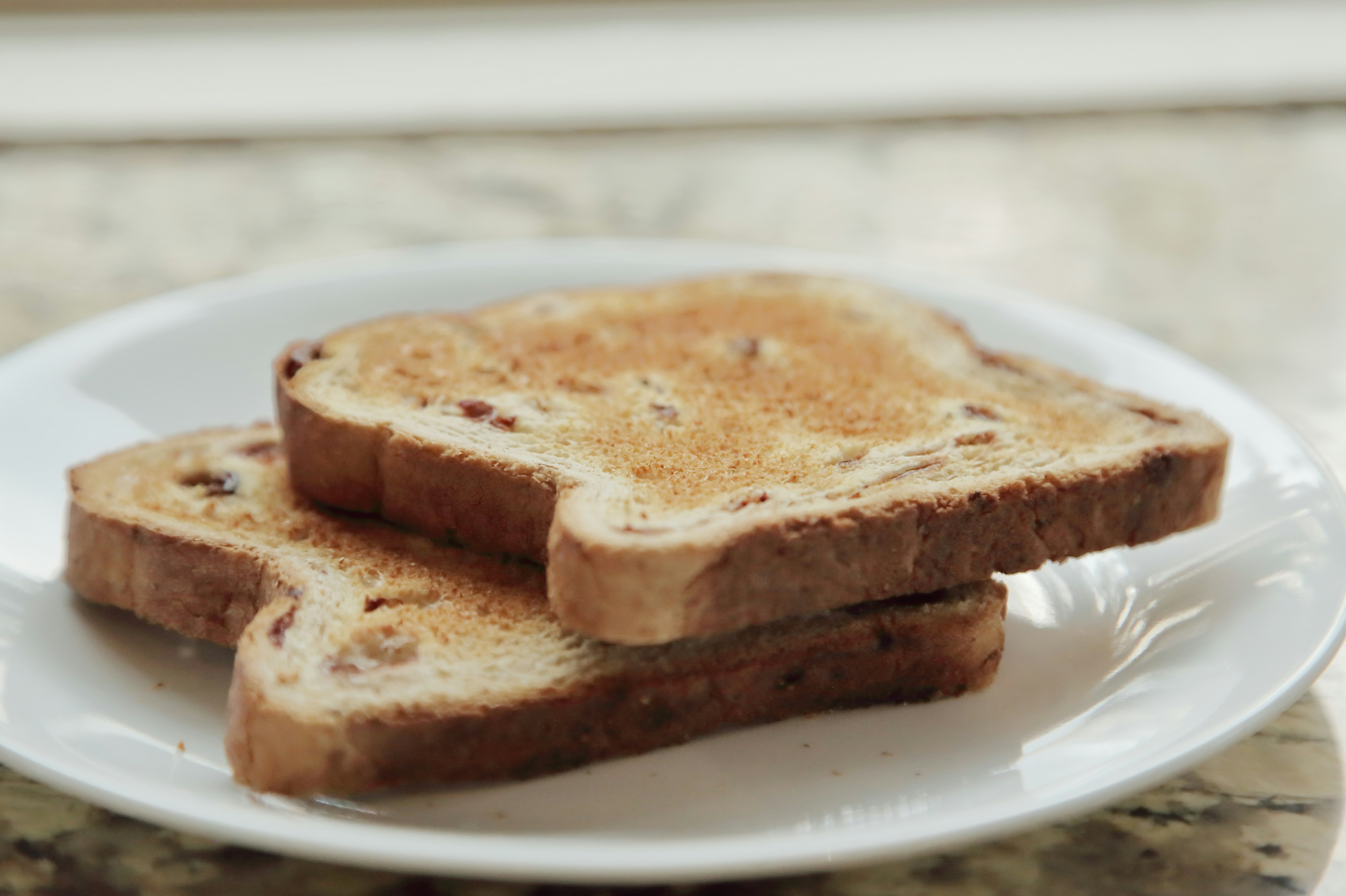 Two slices of toasted bread on a white plate.