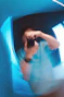 Blurry reflection of person taking a picture in blue light