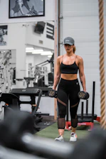 Athletic woman walking in gym with dumbbells