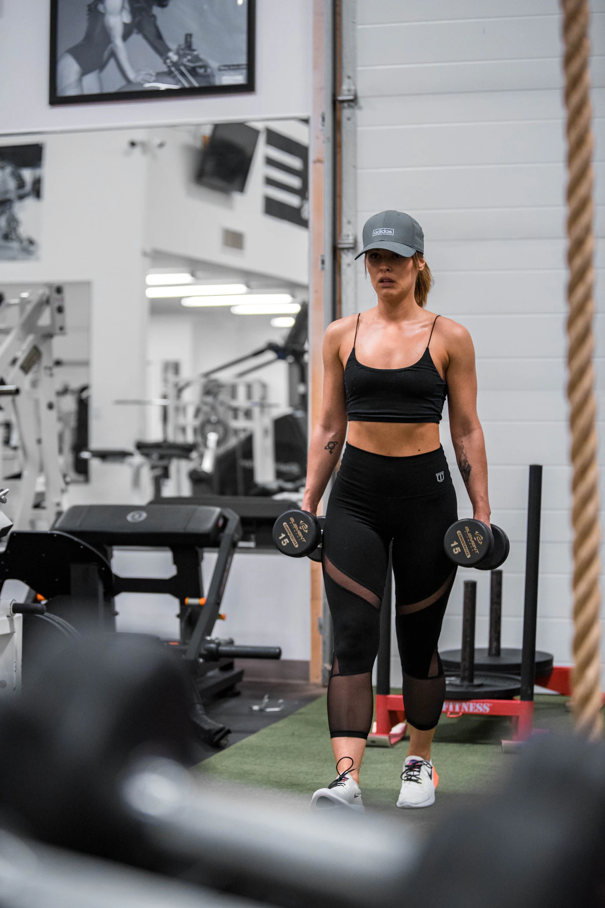 Athletic woman carrying dumbbells in a modern gym