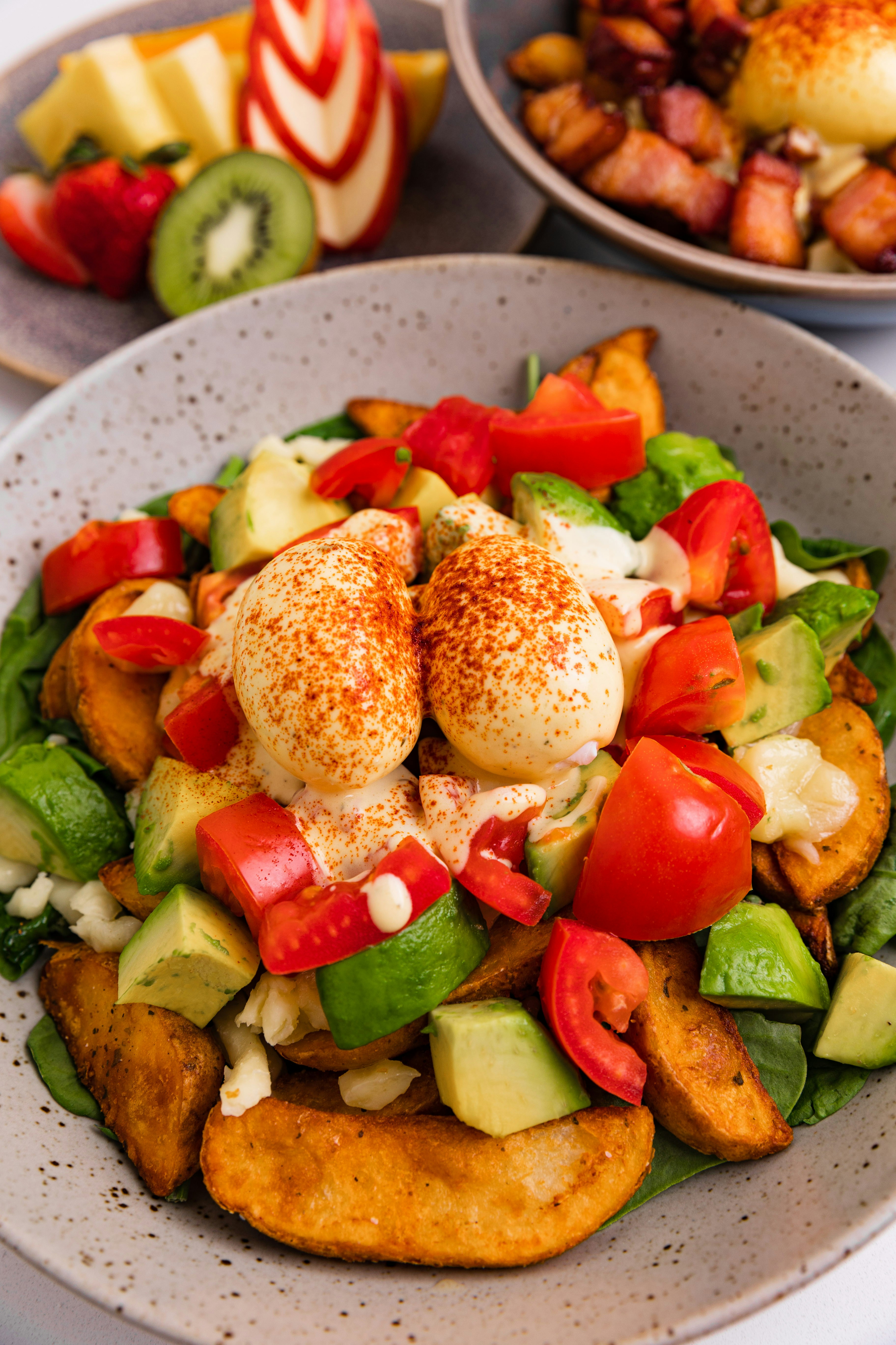 Bol petit-déjeuner avec œufs, avocat, pommes de terre et tomates
