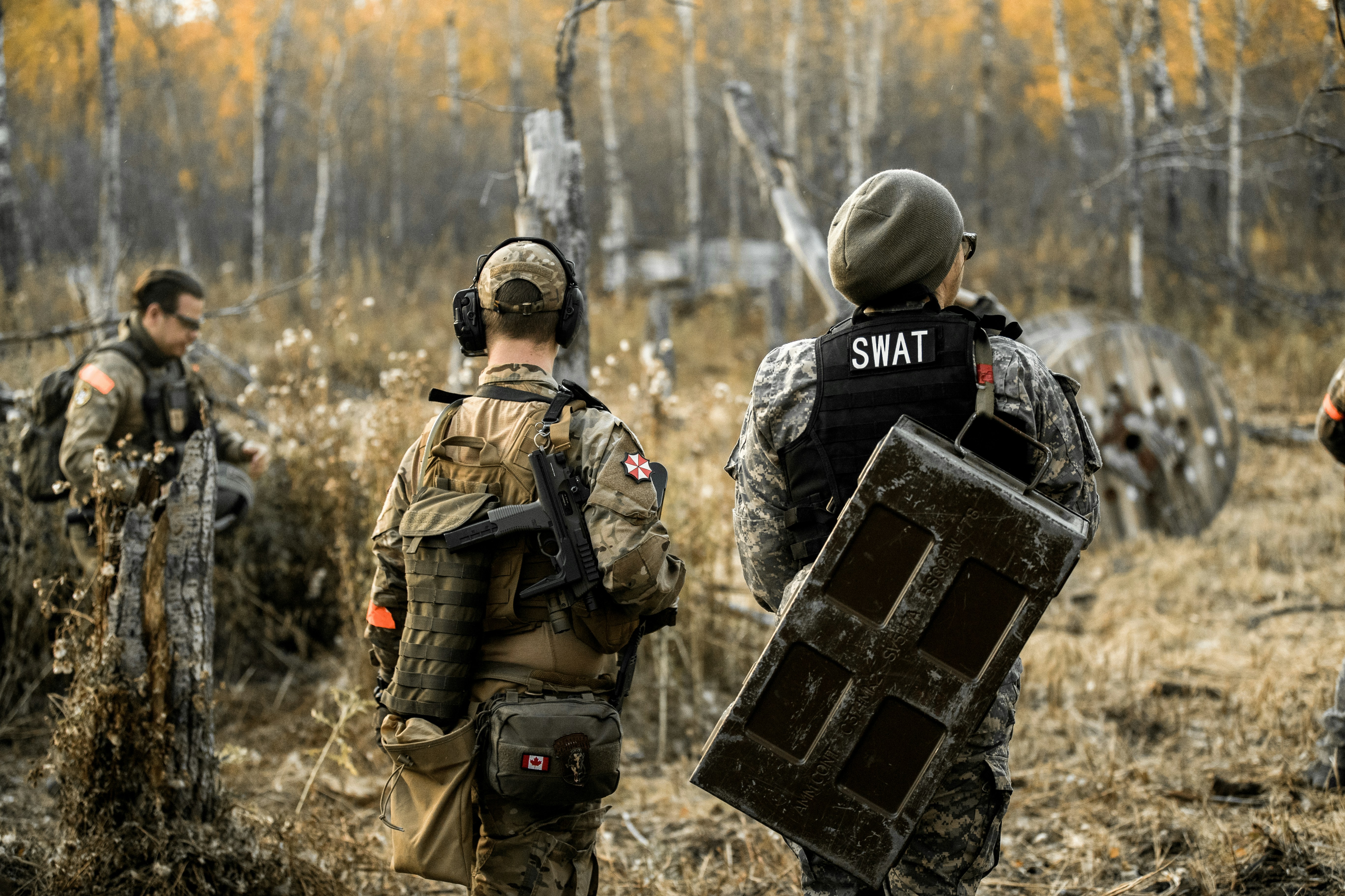 Des membres de l’équipe SWAT avec un bouclier dans une zone boisée