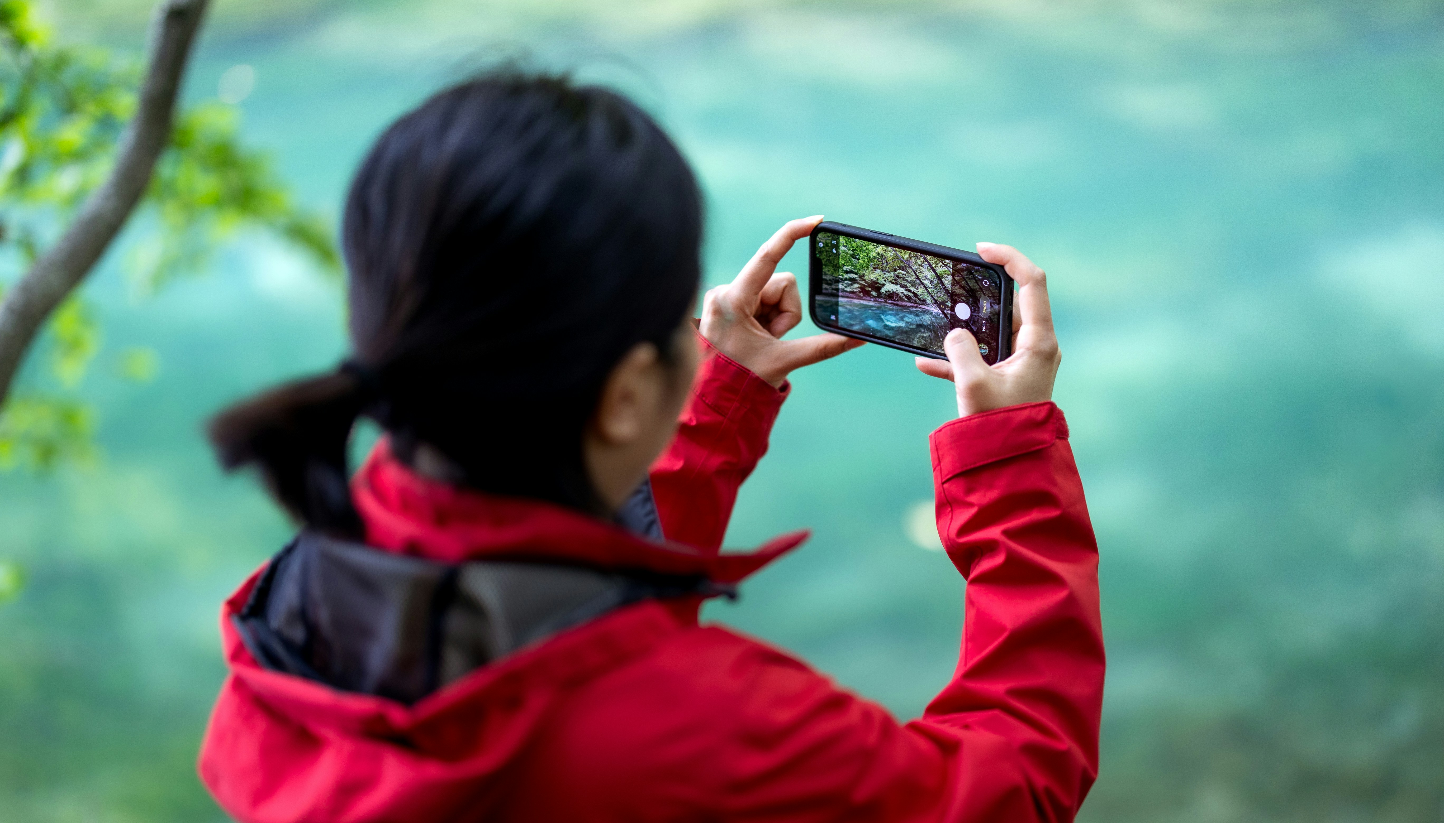 Person capturing a scenic view with a smartphone.