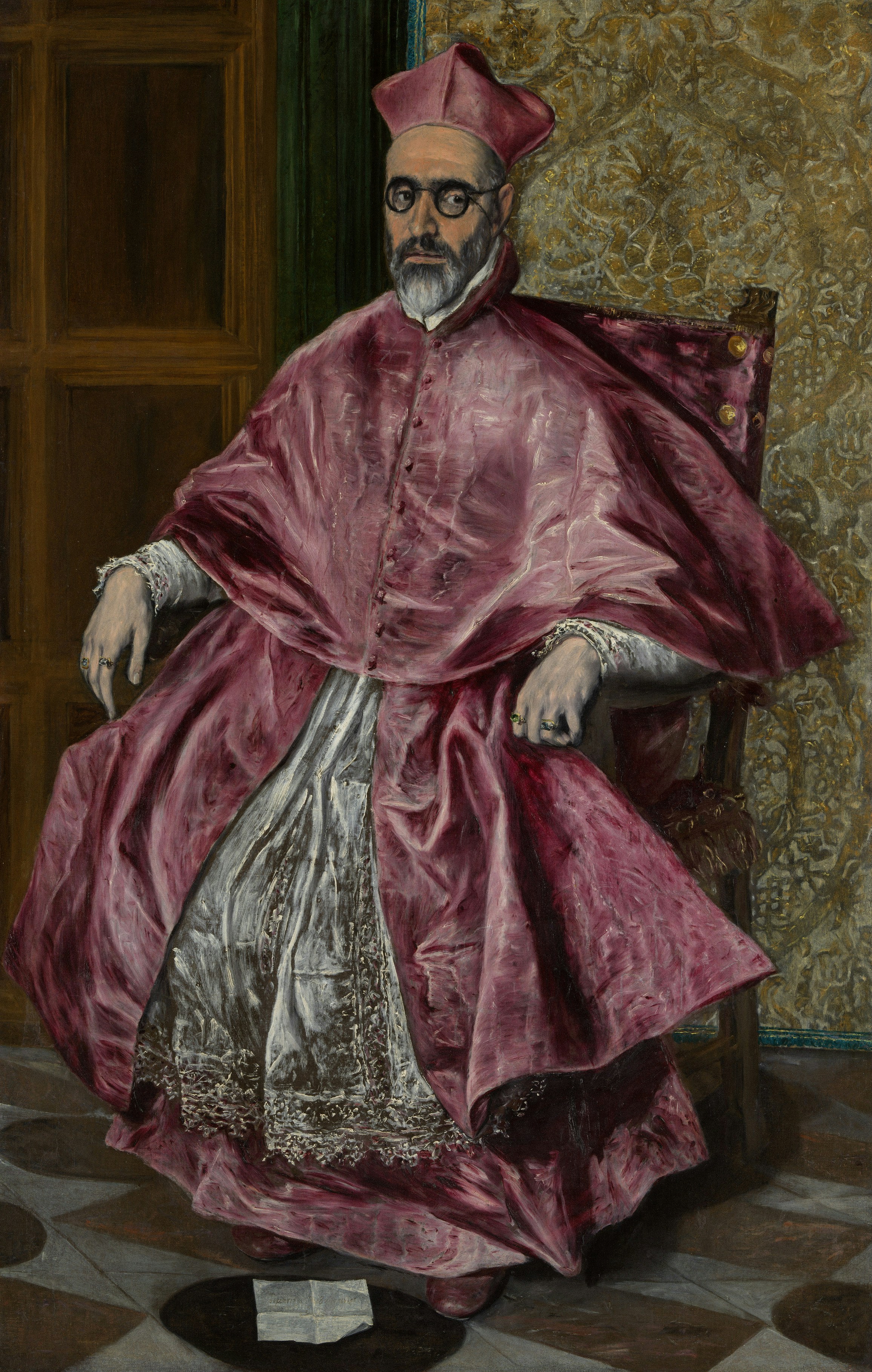 Homme barbu en robe cramoisie et lunettes assis