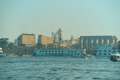 Nile boats passing an ancient riverside temple