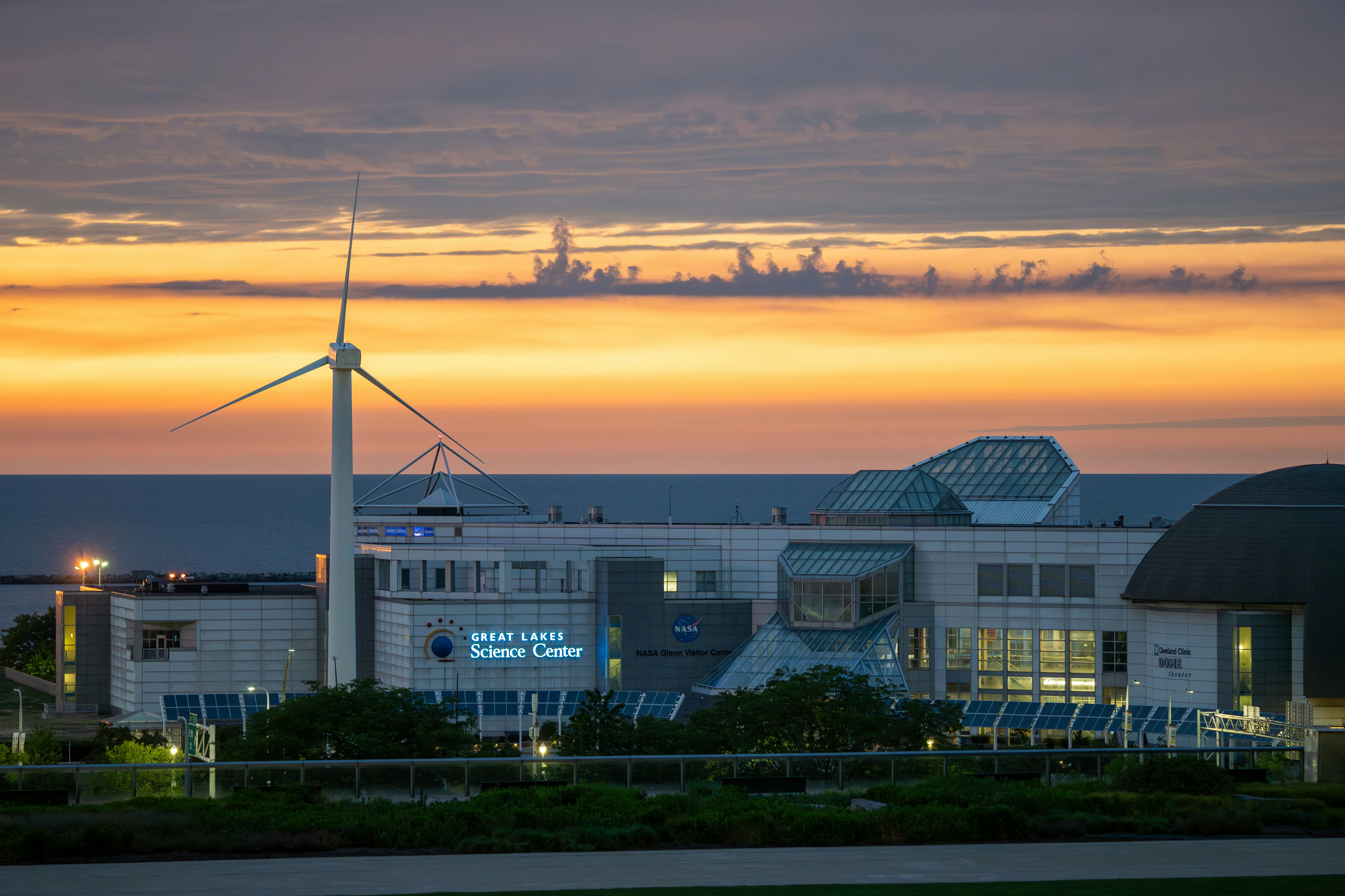 Sunset over great lakes science center and wind turbine.