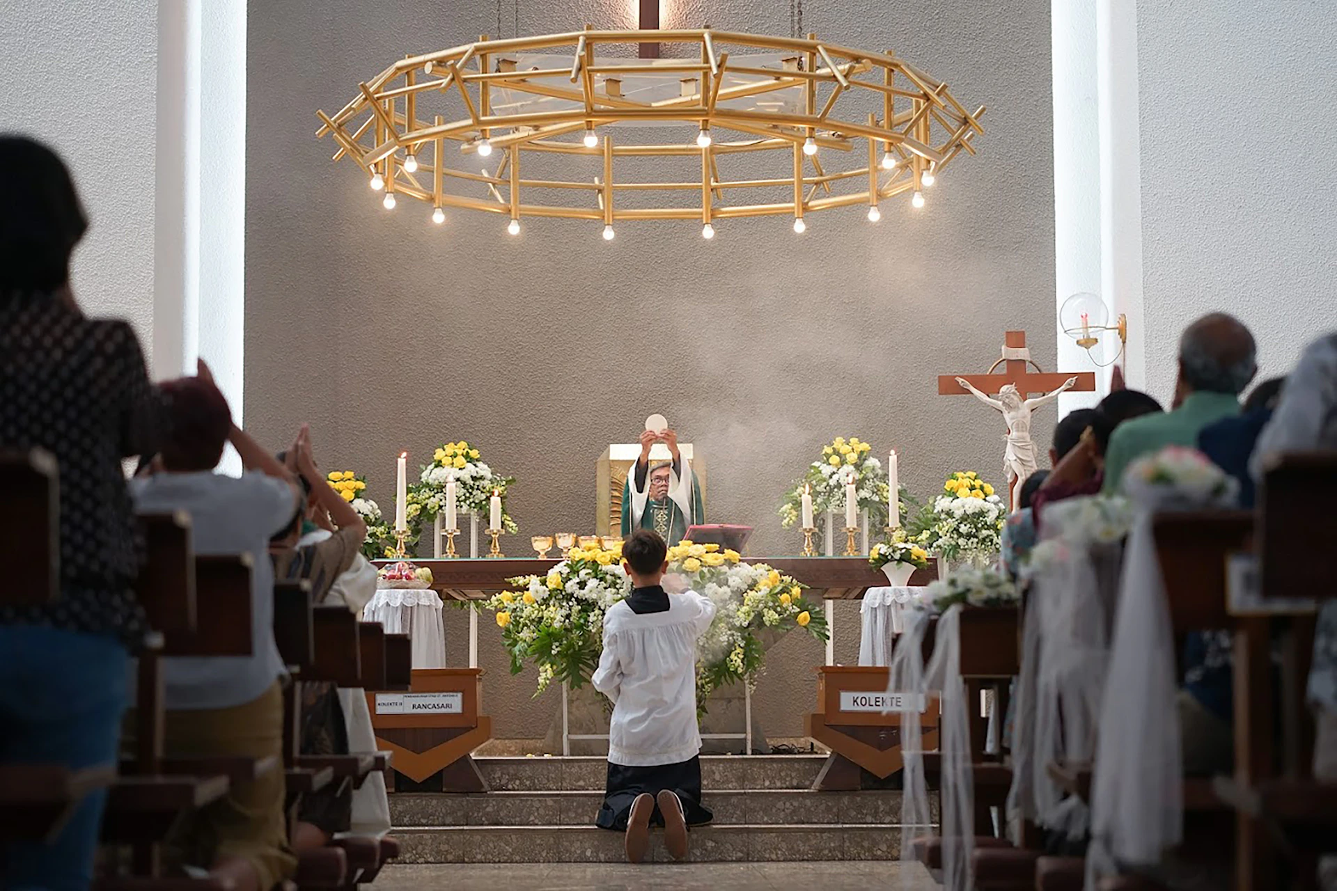 People pray during a church service with a priest