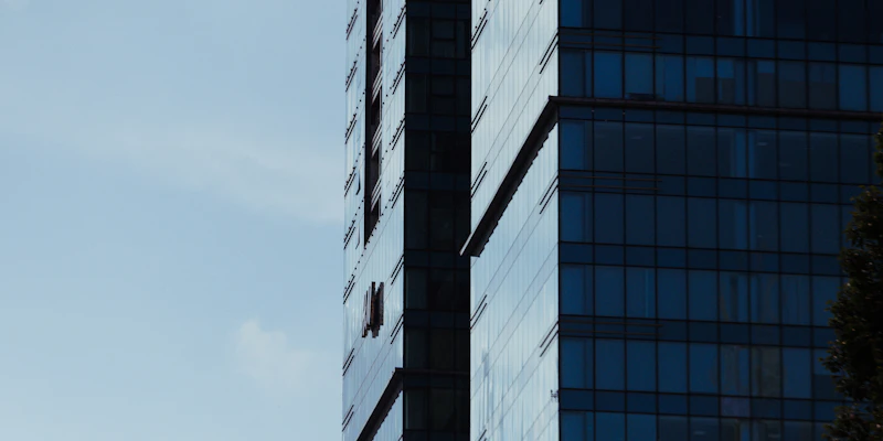 Modern glass office building against a clear blue sky