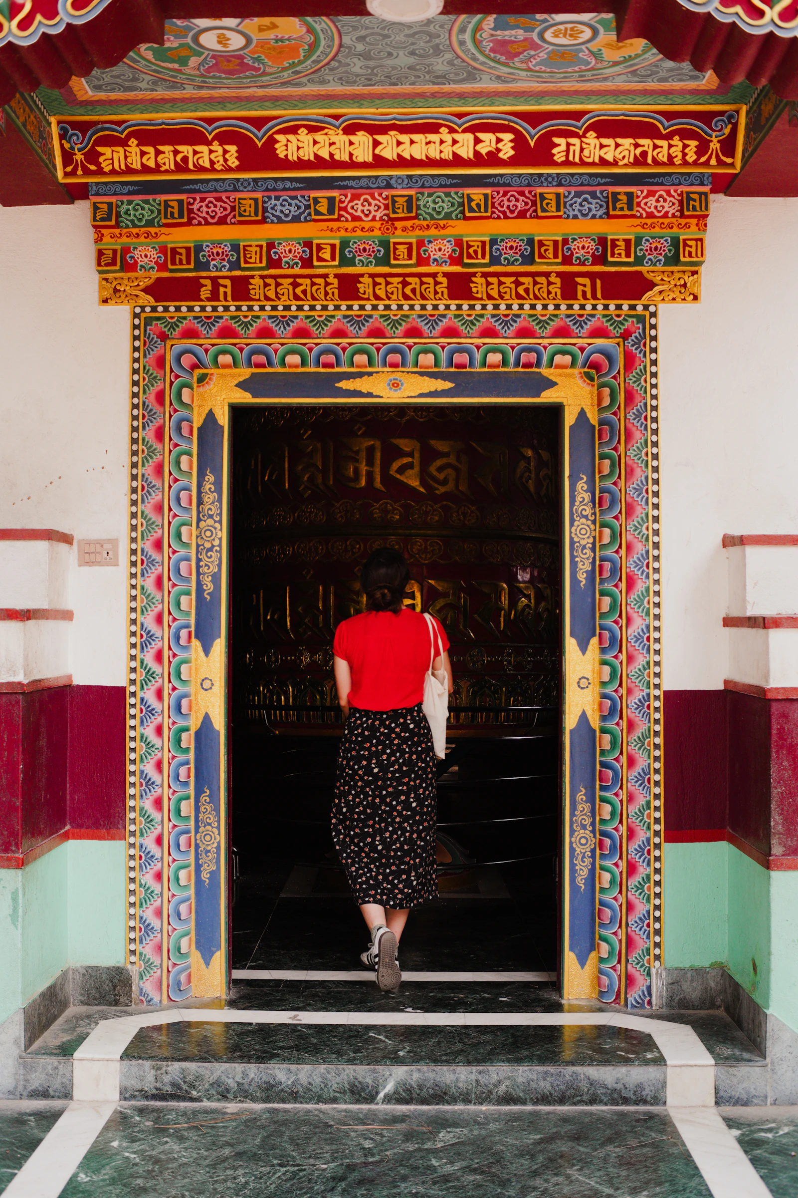 Person entering a colorful temple doorway in Kathmandu