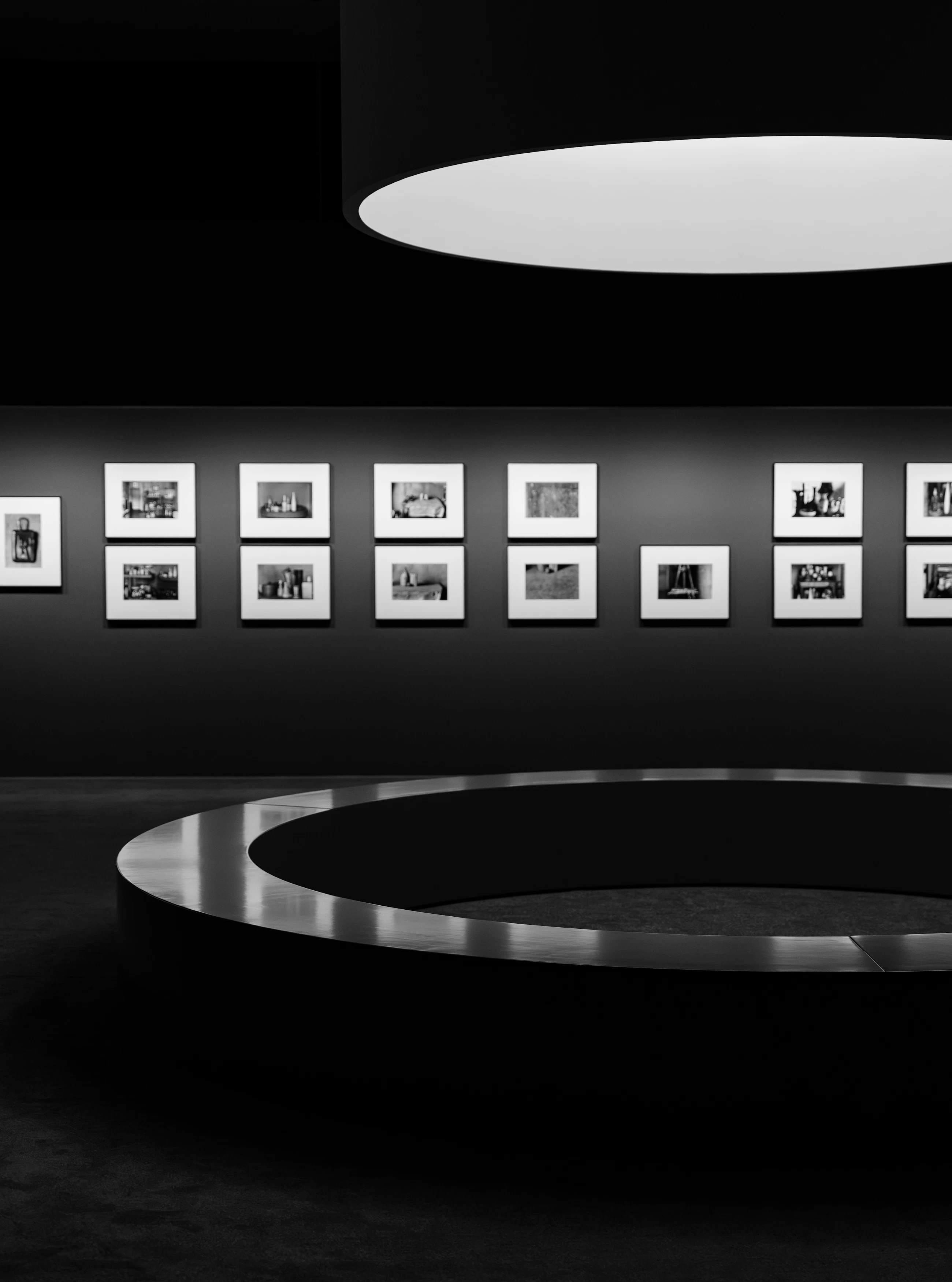 Dark contemporary gallery displaying a series of framed black-and-white photographs