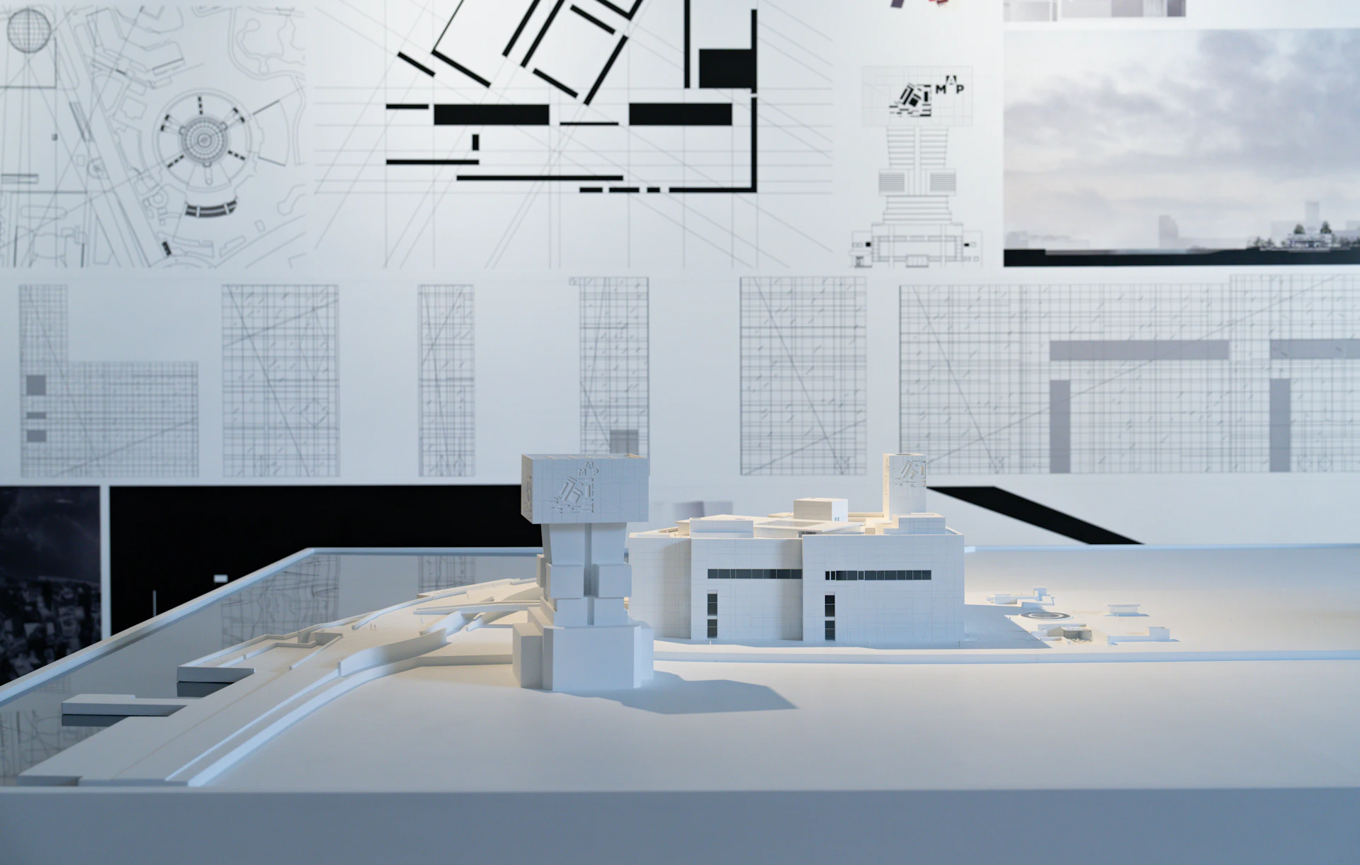 Architectural model with blueprints on wall