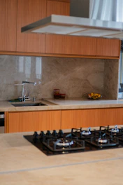 Modern kitchen with wooden cabinets, marble backsplash, and gas stovetop