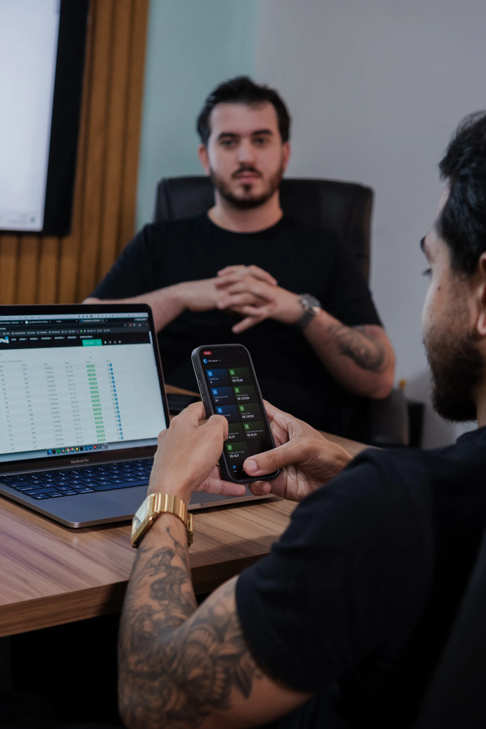 Adults reviewing financial information on a smartphone in an office