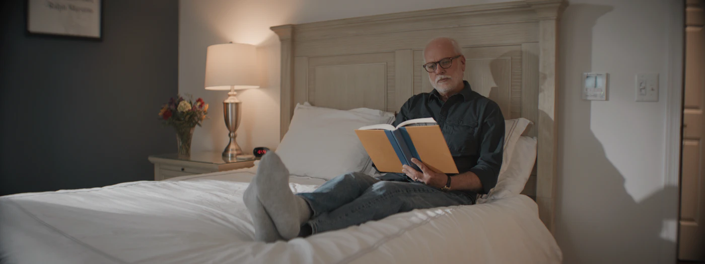 Older man reading a book in bed