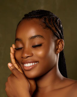 Smiling young woman with braided hair and closed eyes