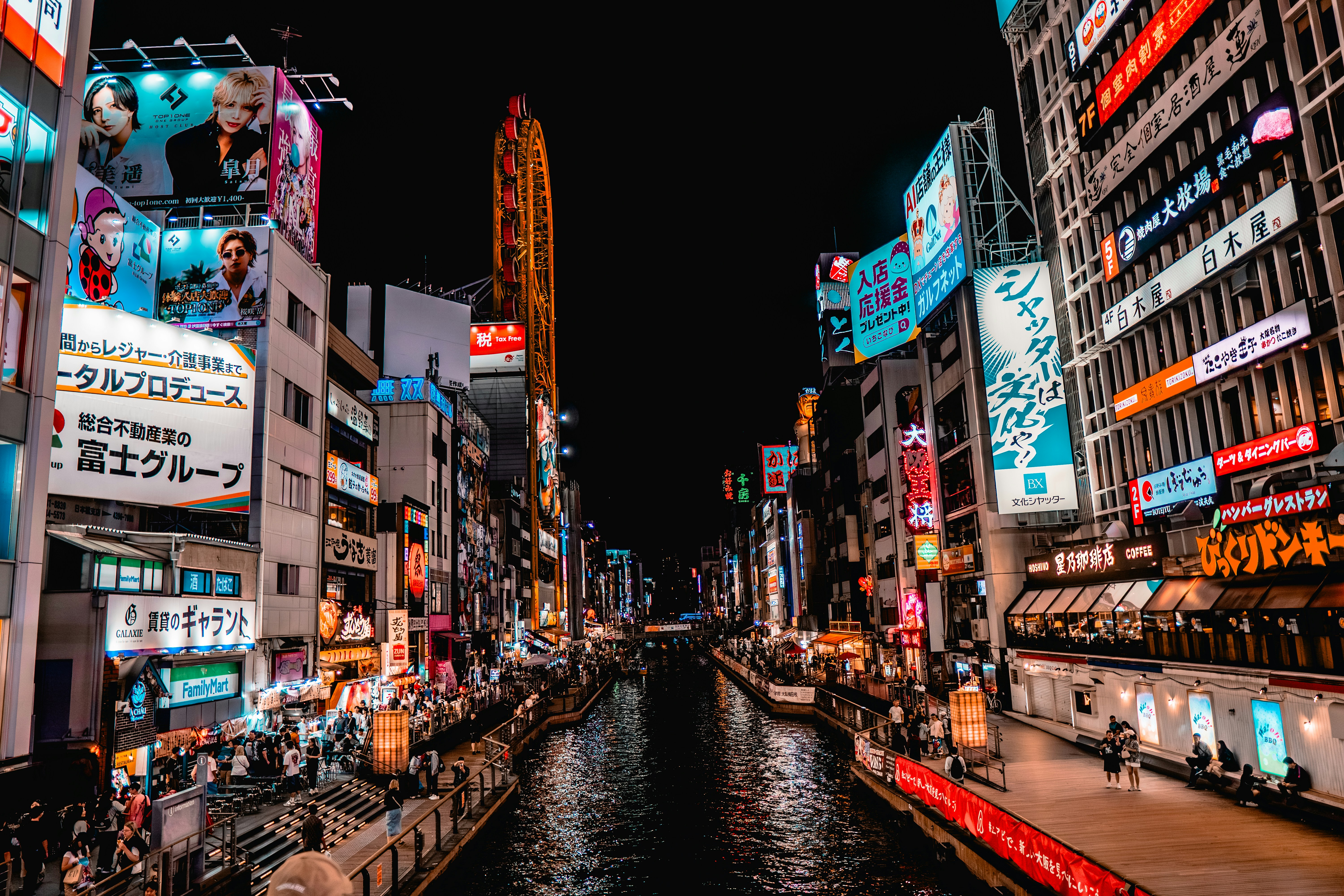 夜の活気ある街並み、明かりに照らされた建物と運河が広がっています。